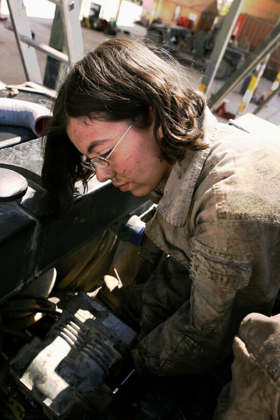 The Logistics Vehicle System is one of several trucks used by Marines to deliver food, water and supplies across Iraq's Al Anbar province. Lance Cpl. Adriana R. Anderson, 22, a mechanic with Maintenance Company's Motor Transport Maintenance Platoon, installs an air compressor after replacing the engine March 27, 2006. Anderson, from Pasadena, Calif., works long hours with other MTM mechanics to support convoys and patrols by their parent command, Combat Logistics Battalion 7, and other units working in northwest Iraq.