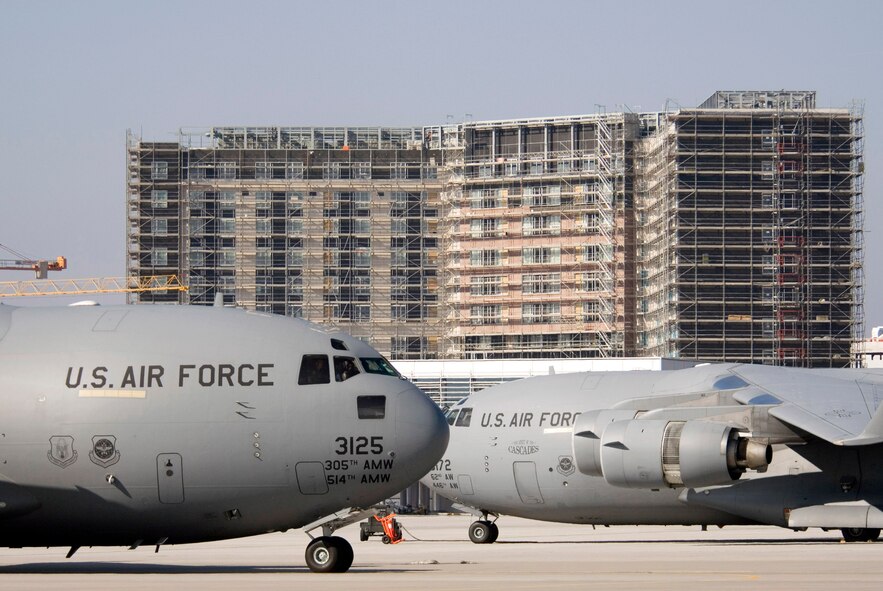 Two C-17 Globemaster IIIs taxi on the busy new ramp while construction of the new hotel continues at Ramstein Air Base, Germany, on Sunday, March 19, 2006.  The 350-room billeting is slated to open in September as part of the Kaiserslautern Military Community Center. (U.S. Air Force photo/Master Sgt. John E. Lasky)