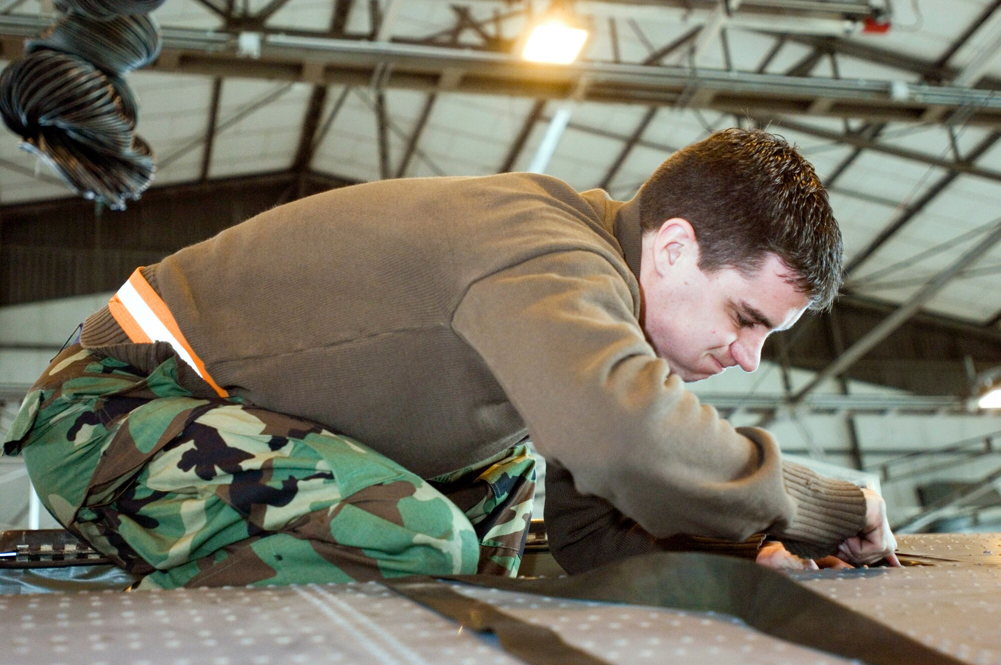 Senior Airman Andrew Tishim installs a life raft on a C-130 Hercules at Ramstein Air Base, Germany, on Monday, March 27, 2006. Airman Tishim is a Hercules crew chief with the 86th Aircraft Maintenance Squadron. (U.S. Air Force photo/Master Sgt. John E. Lasky)