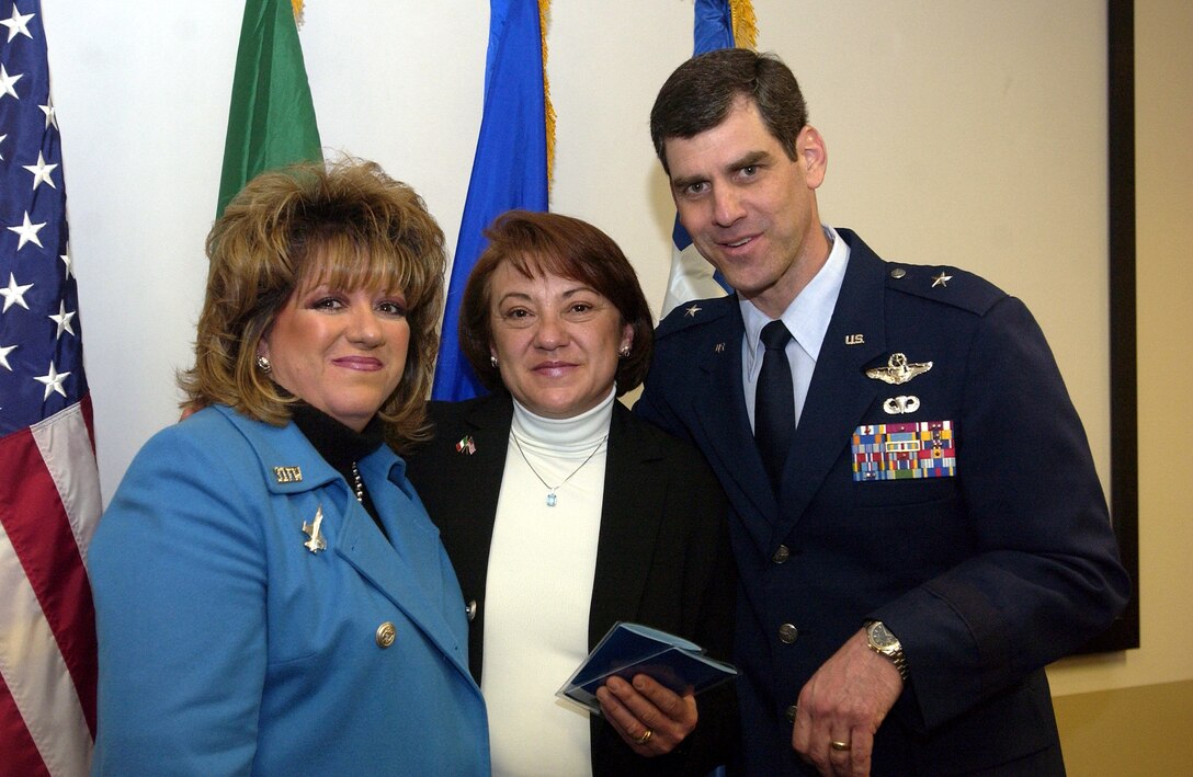 Daniela Scarpolini receives certificates for college funds on behalf of her children from Brig. Gen. Robert Yates, 31st Fighter Wing commander and wife Barbara Yates during a ceremony in honor of her late husband Col. Rosario Scarpolini, former Italian air force commander. (US Air Force photo by Airman Liliana Moreno) 