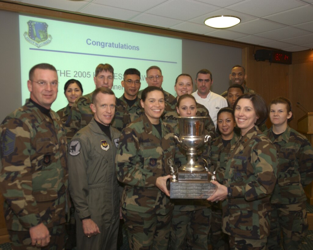 Col. Kent Laughbaum, 48th Operations Group commander, Col. Amanda Gladney, 48th Mission Support Group commander and Chief Master Sgt. Jerry Sutton, 48th Fighter Wing command chief, presents members of the 48th Services Squadron their 2005 USAFE Hennessy trophy Jan. 31 at RAF Lakenheath. 