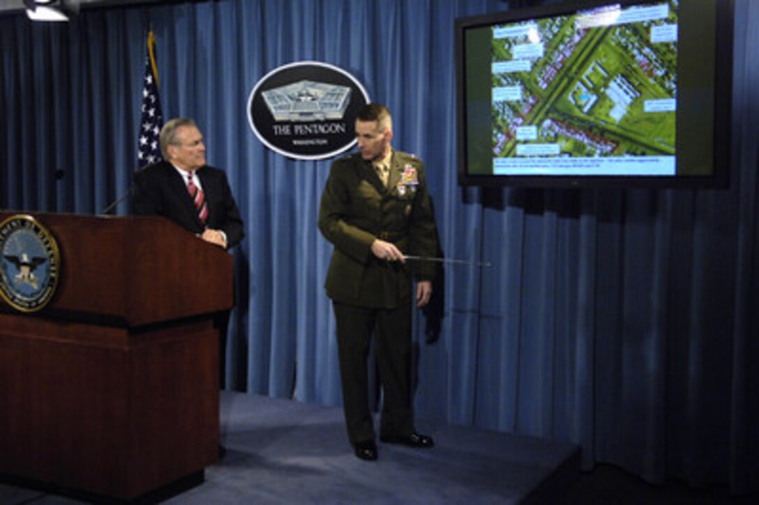 Secretary of Defense Donald H. Rumsfeld watches as Chairman of the Joint Chiefs of Staff Gen. Peter Pace, U.S. Marine Corps, briefs reporters on the March 26th raid by Iraqi Special Operations Forces and coalition advisors on a compound held by a hostage- taking ring during a Pentagon press briefing in Arlington, Va., on March 28, 2006. The Iraqi Special Operations Forces rescued one hostage and found a cache of small arms and materials to make improvised explosive devices in the buildings. 