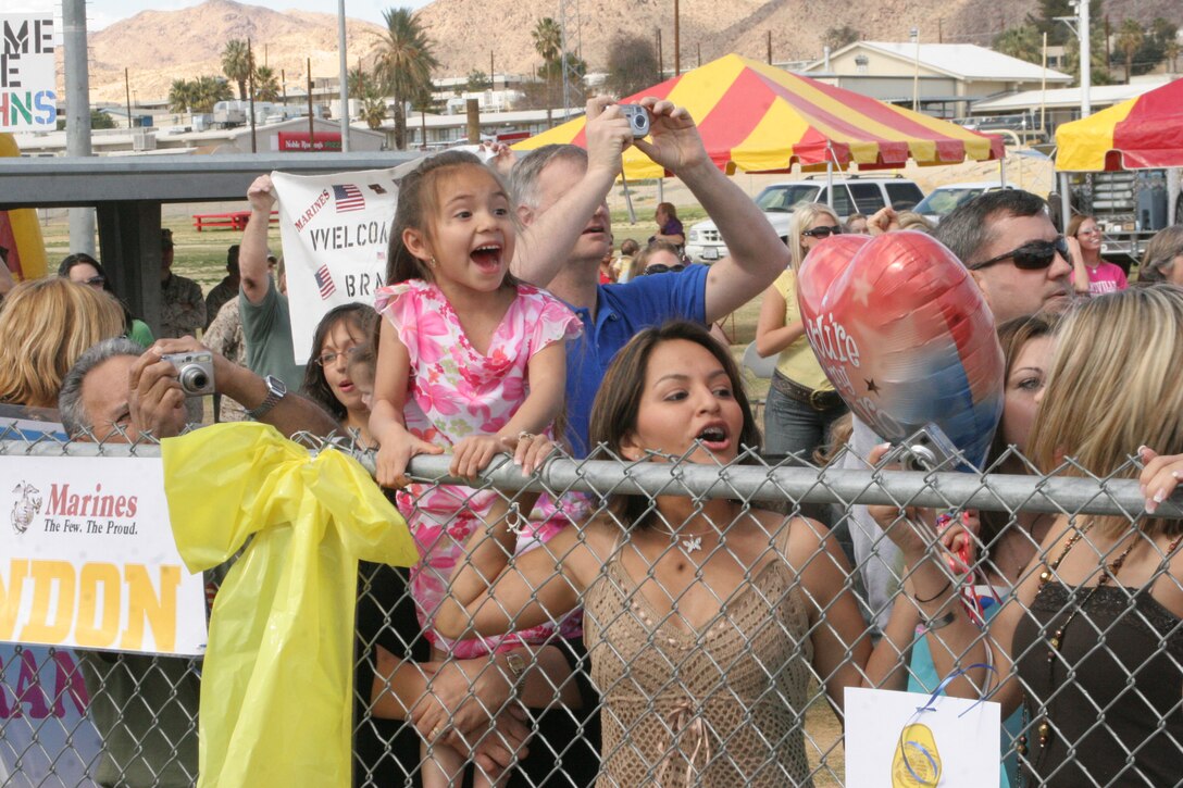 Family members of 3rd Battalion, 7th Marine Regiment cheer as a convoy of buses brings four busloads of Marines and Sailors back to the Combat Center to reunite with their family March 29.