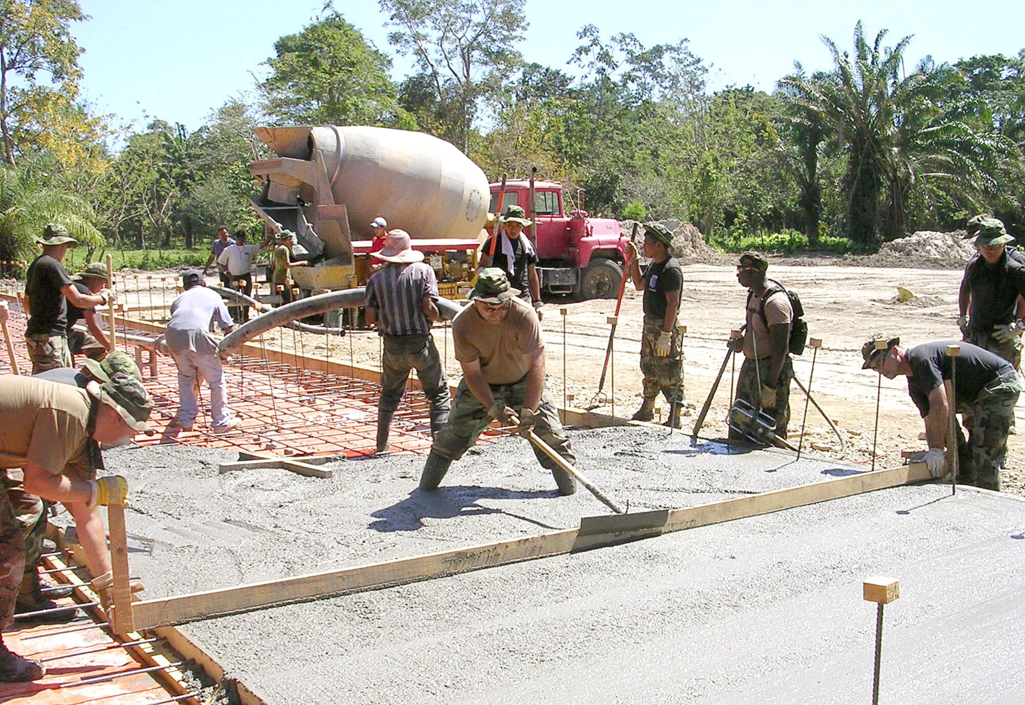 Tech. Sgt. Tim Parault (middle) helps smooth a concrete foundation.  Sergeant Parault is among 17 Airmen deployed from the 354th Civil Engineer Squadron at Eielson Air Force Base, Alaska, in support of New Horizons 2006-Honduras.  The 354th is building a three-classroom school in the small village of El Cacao.  (U.S. Air Force photo/2nd Lt. Sean Stapler)
