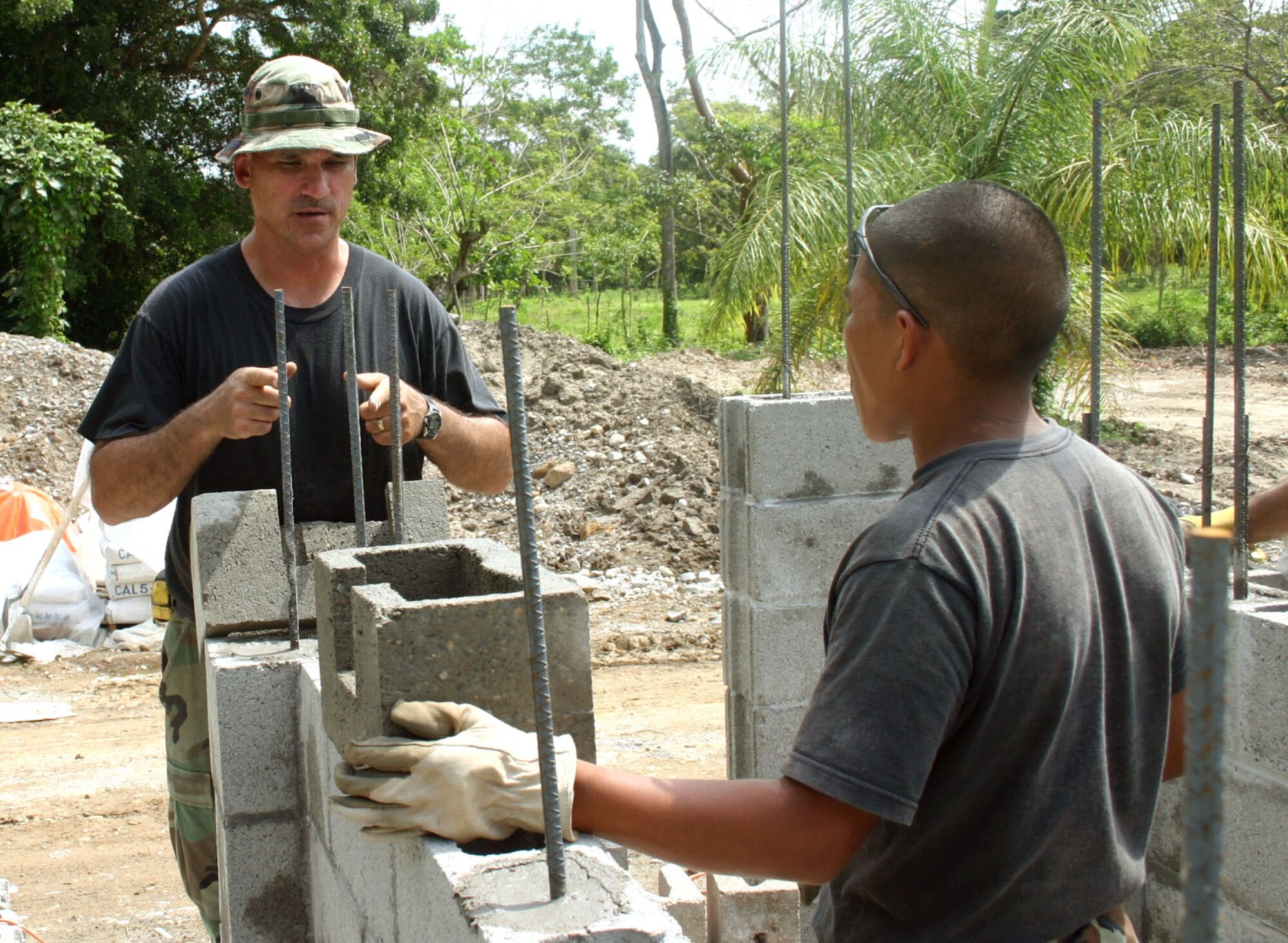 Master Sgt. Brad Johnson talks to Rutilio Mendez, a Honduran engineer, about some cuts that need to be made to a concrete block before it can be placed.  Sergeant Johnson is one of 17 Airmen deployed from the 354th Civil Engineer Squadron at Eielson Air Force Base, Alaska, in support of New Horizons 2006-Honduras.  The 354th is building a three-classroom school in the small village of El Cacao, Honduras. (U.S. Air Force photo/Capt. Mike Chillstrom)
