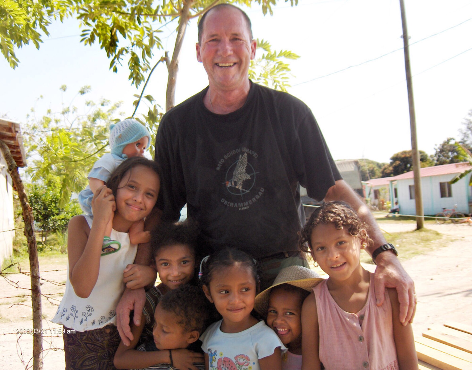 3/21/2006 - LA CEIBA, Honduras -- Col Mike Higginson, 940th Mission Support Group commander, poses with local children near the worksite where the 940th Civil Engineer Squadron is building a school in Honduras March 21, 2006.  New Horizons 2006-Honduras is a joint training exercise between the U.S. military and the Honduran government that will improve the quality of life for the local people. When the exercise concludes in May, the Joint Task Force here will have constructed a maternity clinic, four schools and provided free medical care at 14 different locations in and around La Ceiba. (U.S. Air Force courtesy photo)