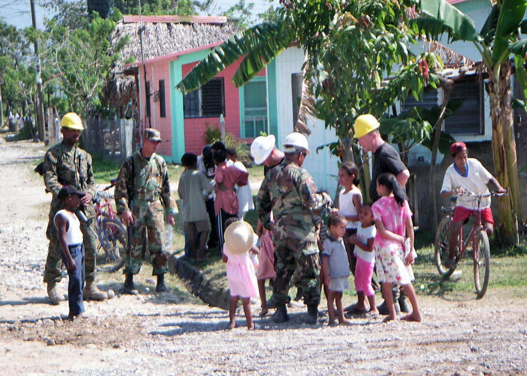 3/21/2006 - LA CEIBA, Honduras  Air Force Reservists and Honduran soldiers greet local children near the worksite where the 940th Civil Engineer Squadron is building a school here.  New Horizons 2006-Honduras is a joint training exercise between the U.S. military and the Honduran government that will improve the quality of life for the local people. When the exercise concludes in May, the Joint Task Force here will have constructed a maternity clinic, four schools and provided free medical care at 14 different locations in and around La Ceiba. (U.S. Air Force photo by Master Sgt. William A. Smith William, Jr.)