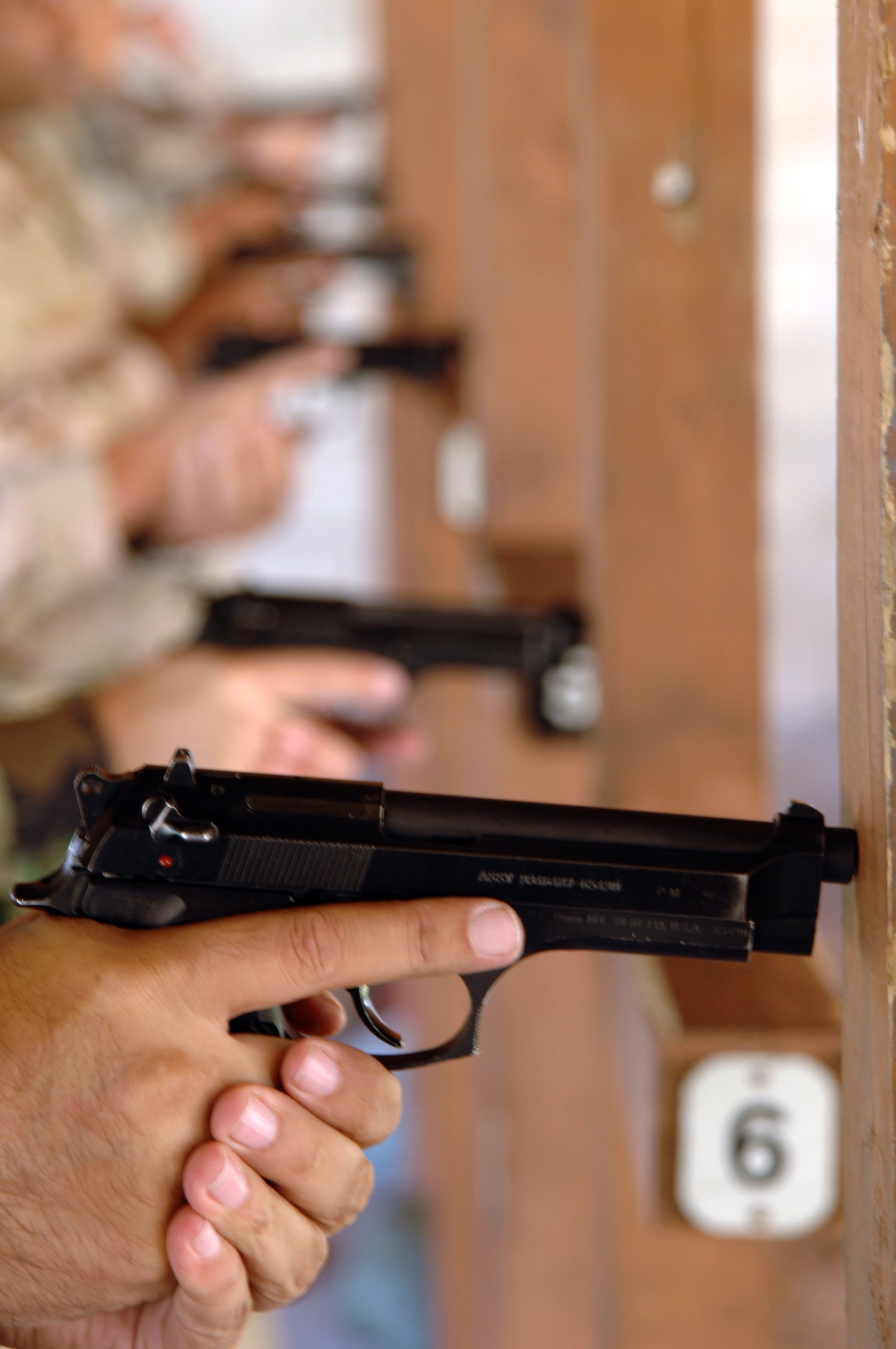 Servicemembers assigned to MacDill Air Force Base, Fla., take safety measures before firing the Beretta M-9 pistol during a combat arms training and maintenance class at MacDill Air Force Base, Fla., on Monday, March 27, 2006.  The instructors teach servicemembers and Department of Defense civilians how to maintain and safely operate fire arms. (U.S. Air Force photo/Senior Airman Jason P. Robertson)