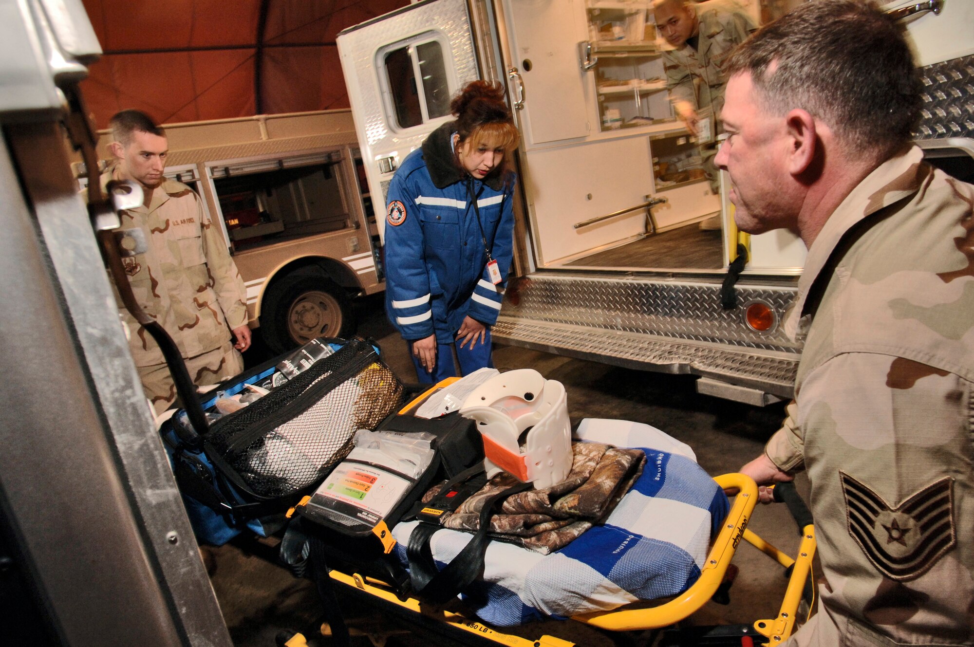 Tech. Sgt. Donald Evans (right) demonstrates the easy height adjustment of the rescue ambulance litter to Nurlaeva Gulzan during a visit by Kyrgyz emergency responders Saturday, March 18, 2006, at Manas Air Base, Kyrgyzstan. Sergeant Evans is deployed to the 376th Expeditionary Medical Squadron from the Nevada Air National Guard's 152nd Medical Group in Reno, Nev. (U.S. Air Force photo/Master Sgt. Lance Cheung)