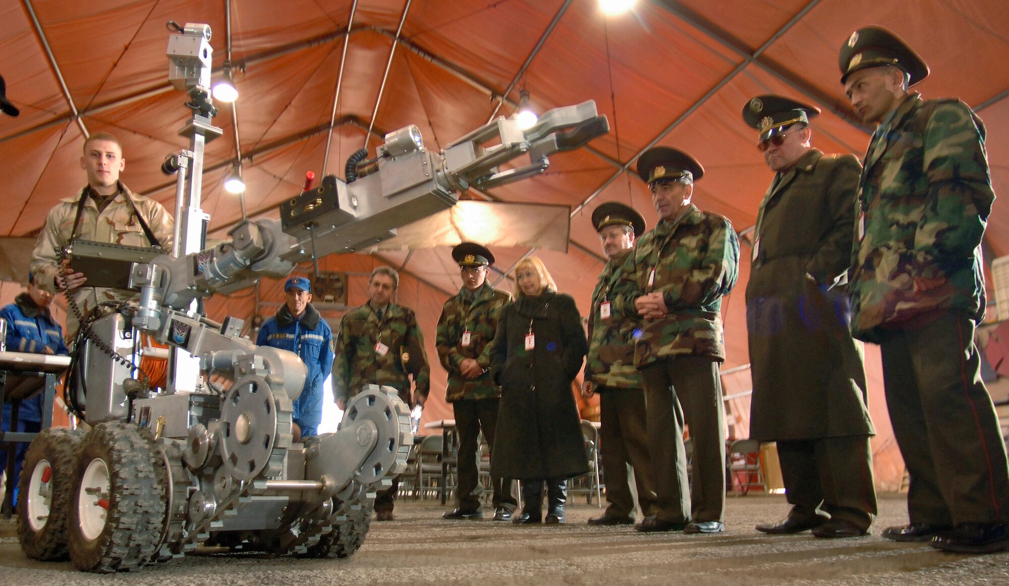 Senior Airman Robin Cunningham controls the mechanical arm of an explosive ordnance disposal robot for Kyrgyz emergency responders Saturday, March 18, 2006, at Manas Air Base, Kyrgyzstan. Airman Cunningham, an explosive ordnance disposal specialist, is deployed to the 376th Expeditionary Civil Engineer Squadron from the 509th CES at Whiteman Air Force Base, Mo.  (U.S. Air Force photo/Master Sgt. Lance Cheung)