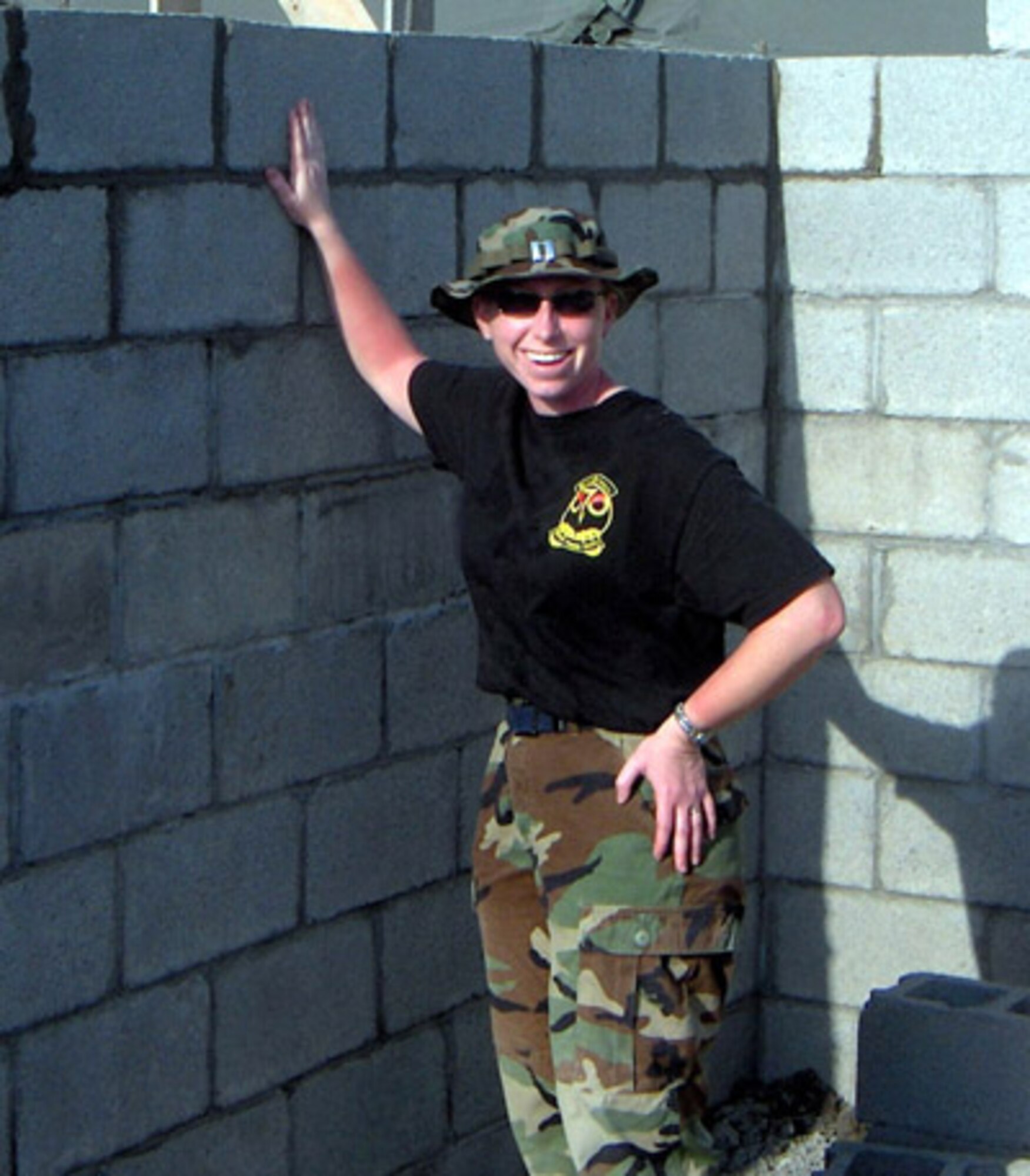 Capt. Heidi K. Palmer, 940th Civil Engineer Squadron, poses in front of a newly formed wall in La Ceiba, Honduras Mar. 7, 2006.   Capt. Palmer was deployed in support of New Horizons 2006, a joint training exercise between the U.S. military and the Honduran government. (U.S. Air Force courtesy photo)