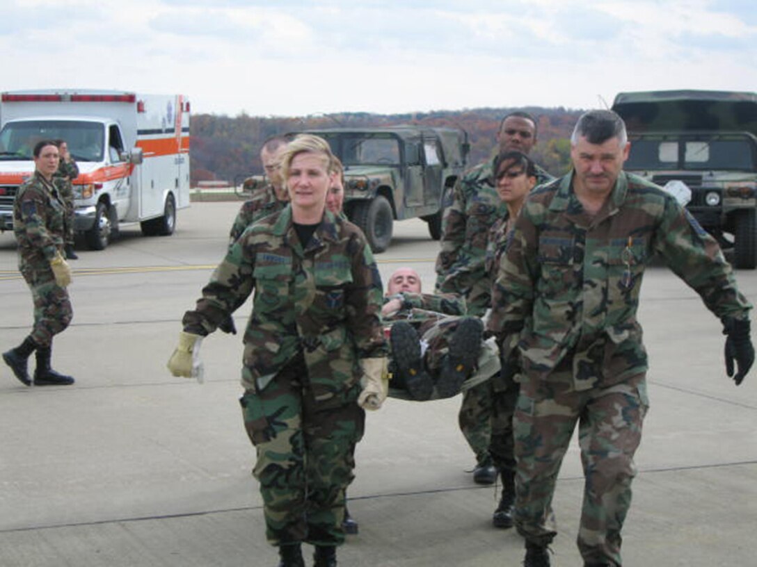 After transporting a patient to the flight line during Patriot Care 2006, litter carriers from the 911th Aeromedical Staging Squadron prepare to on-load a C-130 Hercules. Standing by in the aircraft were 911th Aeromedical Evacuation Squadron personnel tasked to take over the care of the incoming patients.