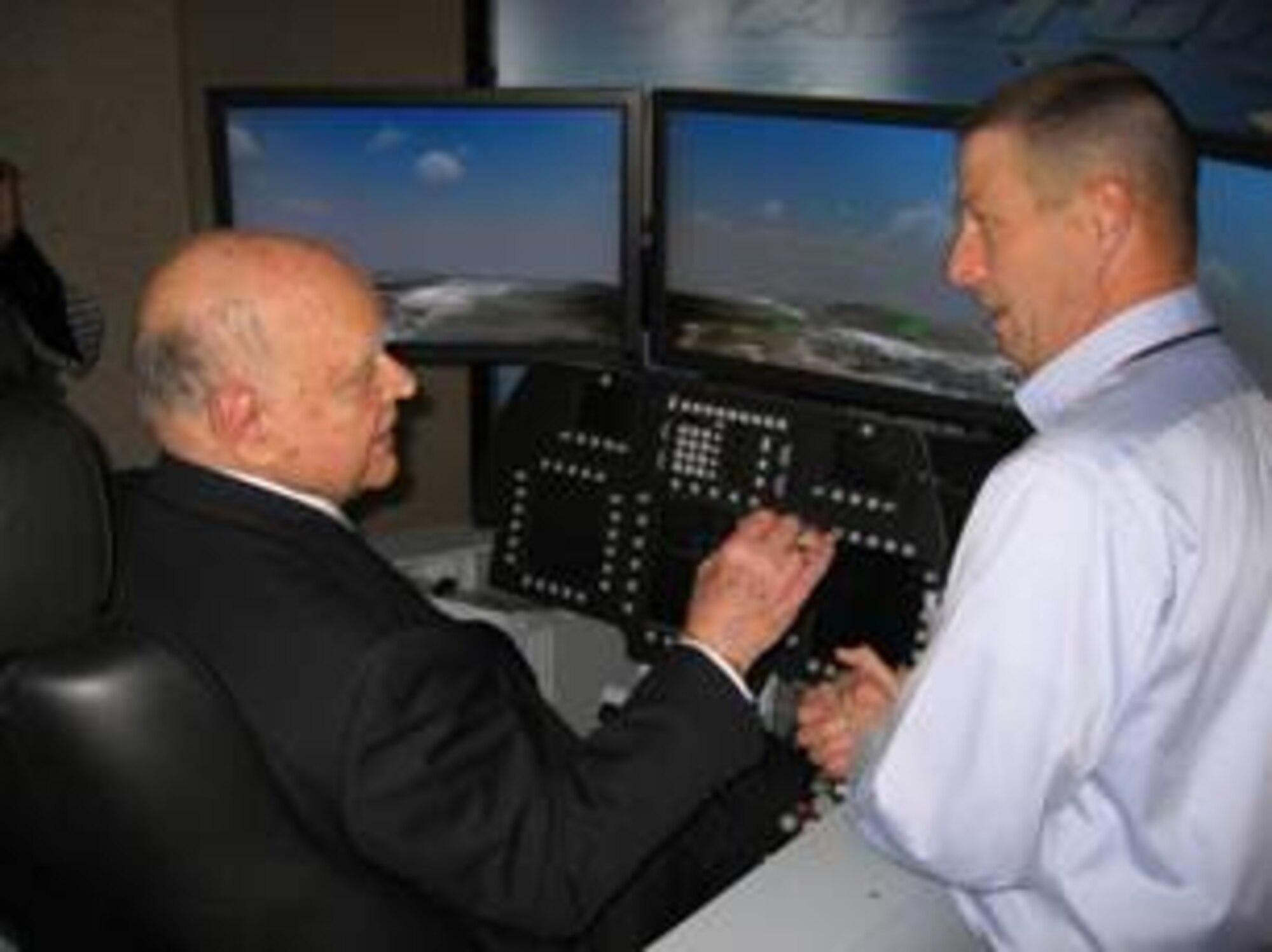 WRIGHT-PATTERSON AIR FORCE BASE, Ohio - Dr. Ralph Davis, recent Distinguished Flying Cross recipient, sits in the cockpit of the F-22A Raptor simulator and gets instructions from Daniel Conroy of Lockheed Martin, Marietta, Ga. (Air Force photo by Laura McGowan)

