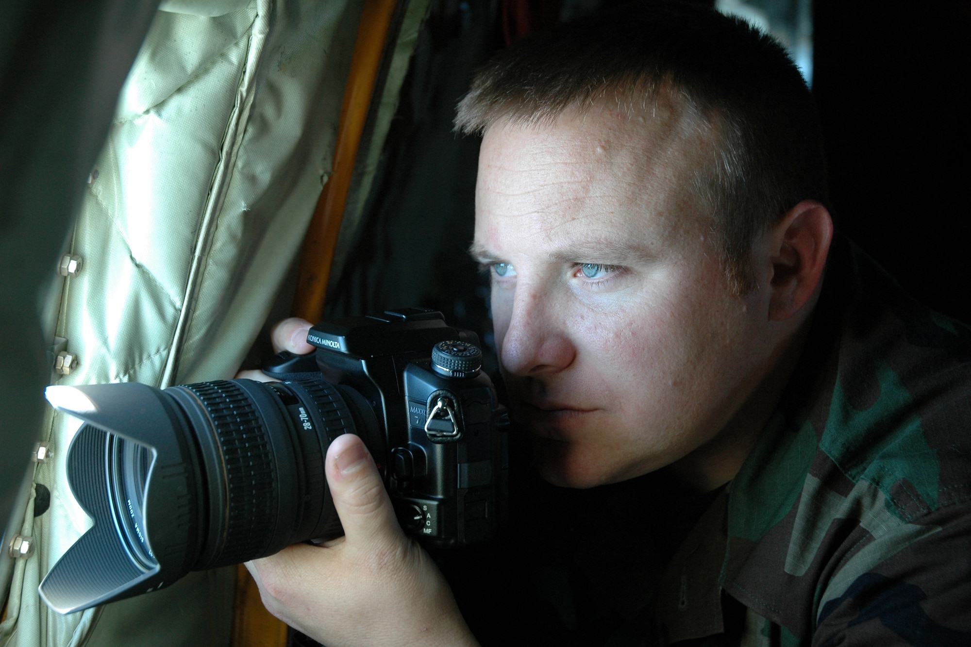 EGLIN AIR FORCE BASE, Fla. - Senior Airman Mike Meares, 96th Air Base Wing public affairs, eyes up a photo aboard a KC-135 during a refueling mission over the Gulf of Mexico. He was recently named the Air Force's Photojournalist of the Year. (Air Force photo by Tech. Sgt. Jeff Stoermer)

