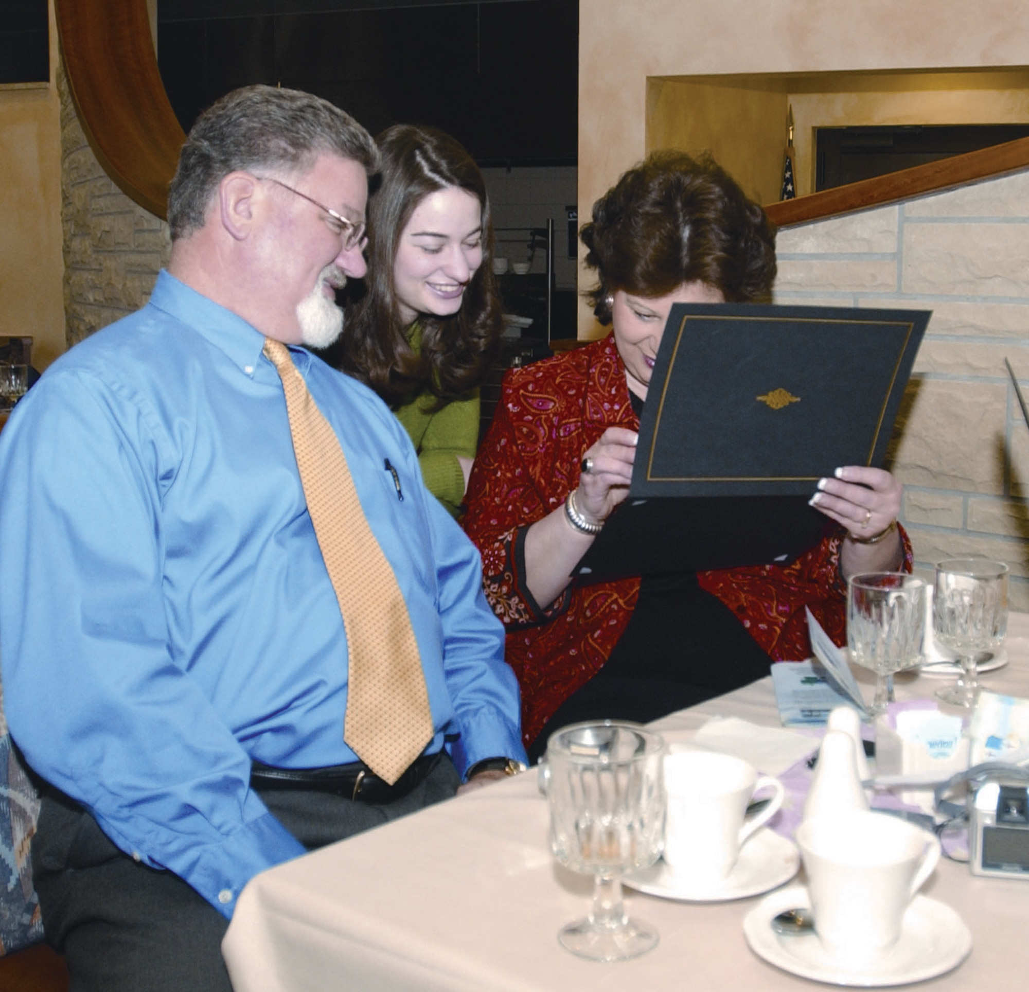 Dave Britt, 52nd Fighter Wing Judge Advocate Office tax consultant, beams at a Commander's Honor Roll certificate with Elizabeth Britt and spouse, Cindy, at the CHR ceremony Tuesday. (U.S. Air Force photo by Airman Emily Moore)