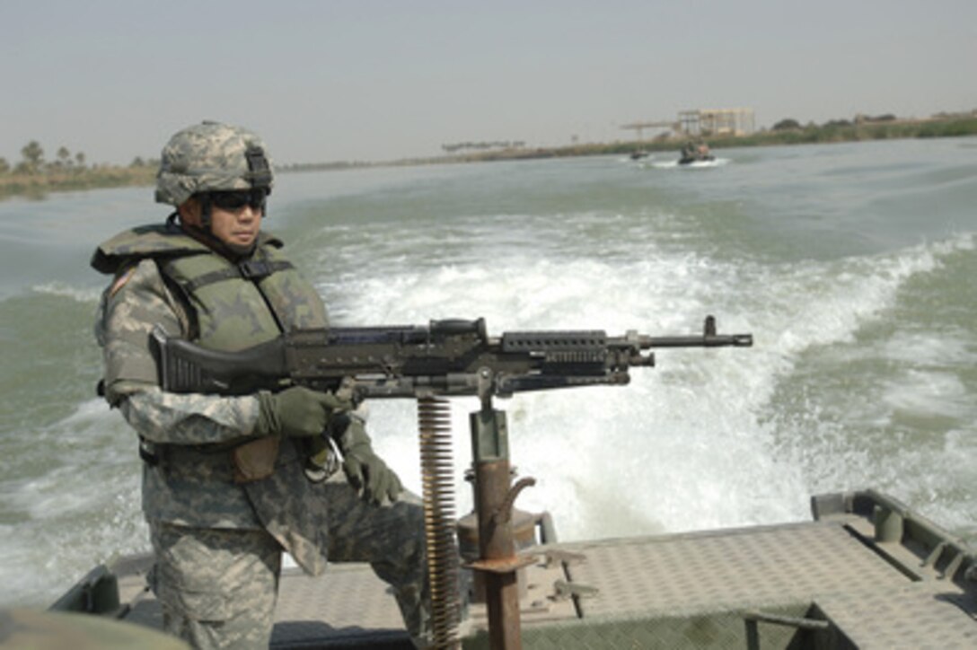 U.S. Army Master Sgt. Nardo Dedicatoria keeps an eye on the shoreline of the Euphrates River during a reconnaissance mission near Musayyib, Iraq, on March 21, 2006. Coalition soldiers are not only patrolling the streets of Iraq, but the waterways as well. Dedicatoria is attached to Echo Company, 1st Battalion, 67th Armored Regiment. 