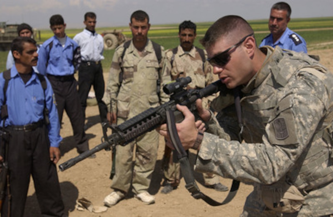 U.S. Army Sgt. Nicholas Sowinski demonstrates shooting techniques to Iraqi police officers during weapons training in Khidr Ilyas, Iraq, on March 29, 2006. Sowinski is with the 4th Battalion, 14th Infantry Regiment, 172nd Infantry Stryker Combat Team. 