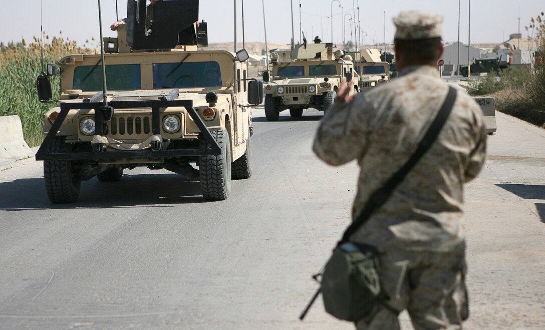 Force protection and other safety issues are a key concern for the Marines of Combat Logistics Battalion 7, 1st Marine Logistics Group, as they carry out their deployment at Al Asad Air Base, Iraq. While on guard, Lance Cpl. Nestor Tecuapetlahuanetl, a 23-year-old native of Los Angeles, checks the identification of all personnel who pass through his gate, whether they are in a vehicle, on a bicycle or walking March 30, 2006. Tecuapetlahuanetl, a truck driver with CLB 7â??s Engineer Company, is currently serving a two-week duty with the guard unit. Aside from their primary mission to provide logistical support to Marine and Iraqi forces in places like Ramadi, Hadithah, and Al Qaim, the battalion is also training Iraqi soldiers to carry out their own logistics operations.