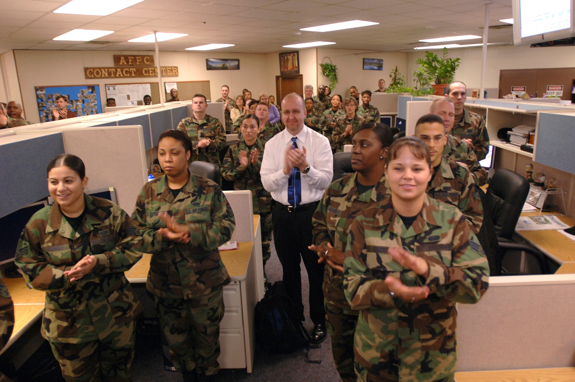 Airmen and civilians working at the Air Force Personnel Center's contact center applaud the operational beginning of the new Personnel Service Delivery System on Friday, March 31, 2006, at Randolph Air Force Base, Texas. (U.S. Air Force photo/Tech. Sgt. Cecilio Ricardo Jr.)