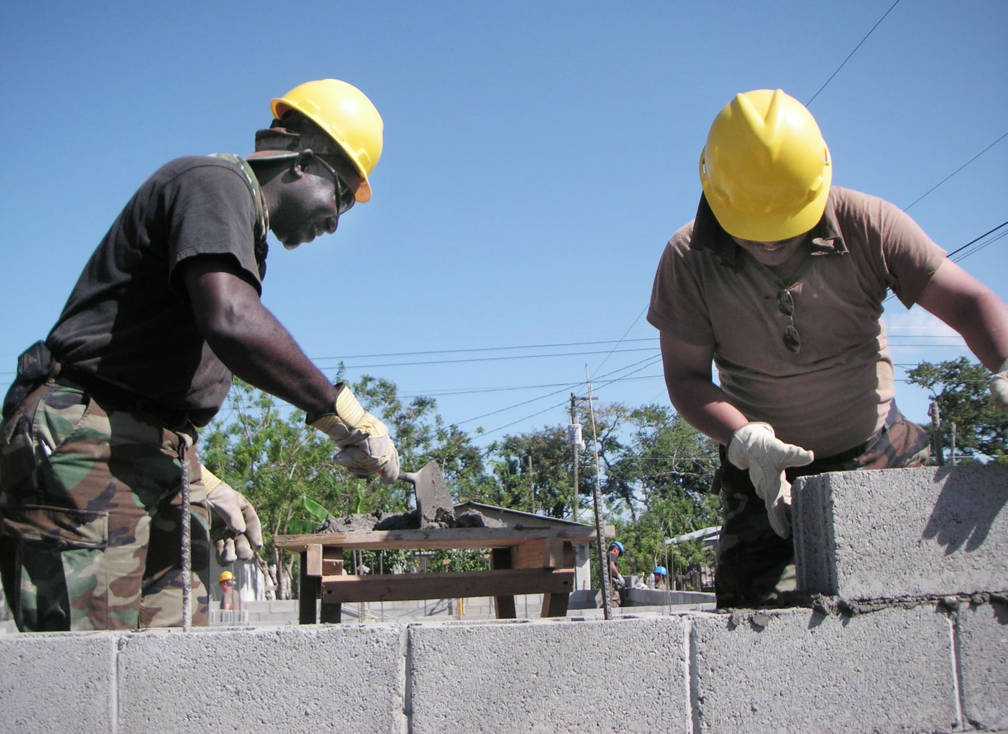 3/21/2006 - LOS GIRASOLES, Honduras -- Senior Master Sgt. Stephen Nnodim, superintendent of utilities (left), and  Master Sgt. Joseph Abitongof, liquid fuels craftsman, the 940th Civil Engineer Squadron, builds a cinder-block wall to be part of a school here. New Horizons 2006-Honduras is a joint training exercise between the U.S. military and the Honduran government that will improve the quality of life for the local people. When the exercise concludes in May, the Joint Task Force here will have constructed a maternity clinic, four schools and provided free medical care at 14 different locations in and around La Ceiba. (U.S. Air Force photo by Master Sgt. William A. Smith, Jr.)