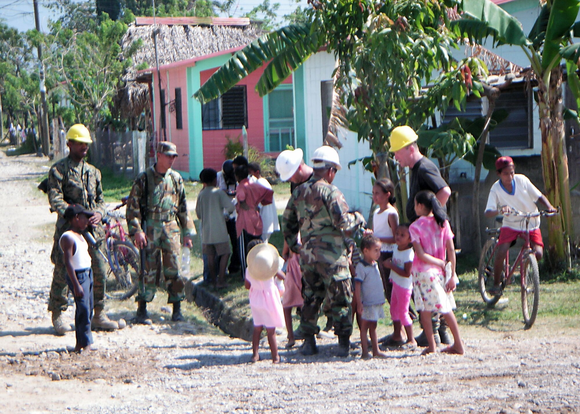 3/21/2006 - LOS GIRASOLES, Honduras -- Air Force Reservists and Honduran soldiers greet local children near the worksite where the 940th Civil Engineer Squadron is building a school here.  New Horizons 2006-Honduras is a joint training exercise between the U.S. military and the Honduran government that will improve the quality of life for the local people. When the exercise concludes in May, the Joint Task Force here will have constructed a maternity clinic, four schools and provided free medical care at 14 different locations in and around La Ceiba. (U.S. Air Force photo by Master Sgt. William A. Smith William, Jr.)