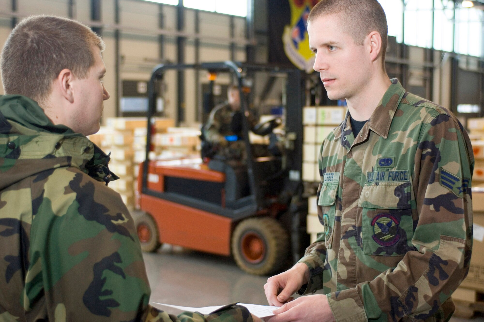 Senior Airman Chad Koerber discusses where to send a load of cargo that arrived by truck with Airman Matthew Flis at Ramstein Air Base, Germany, on Thursday, March 30, 2006. Airman Ballegos, of Warsaw, Kent., and Airman Flis, of Richland, Wash., are cargo processing specialists with the 723rd Aircraft Mobility Squadron. (U.S. Air Force photo/Master Sgt. John E. Lasky)
