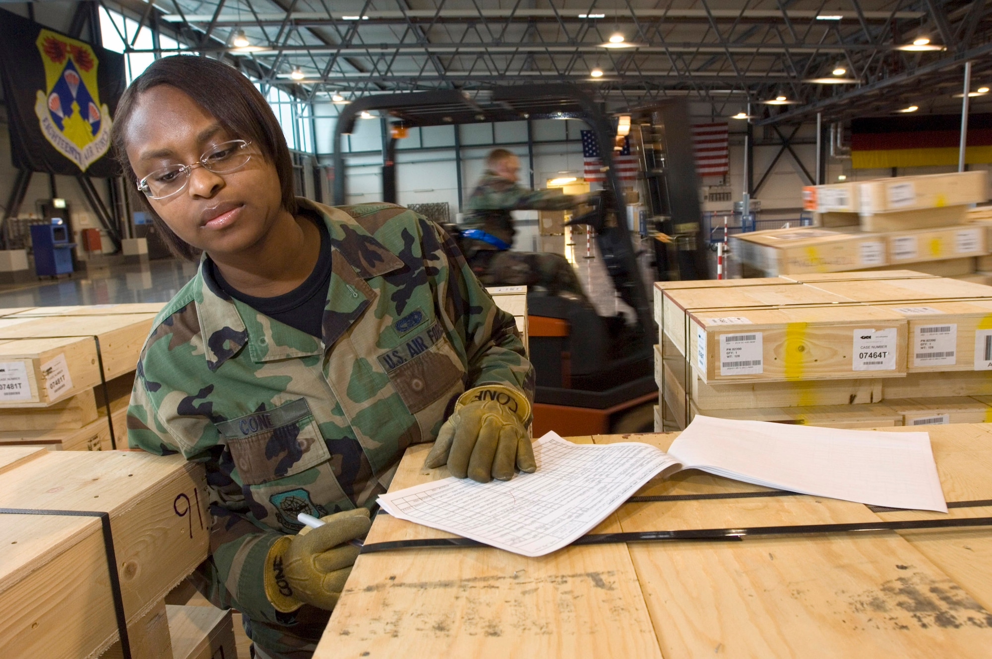 Airman 1st Class Gloria Cone checks pallets full of bulletproof glass bound for Humvees in Iraq as they are unloaded at Ramstein Air Base, Germany, on Thursday, March 30, 2006. Airman Cone is a cargo processing specialist with the 723rd Air Mobility Squadron. (U.S. Air Force photo/Master Sgt. John E. Lasky)