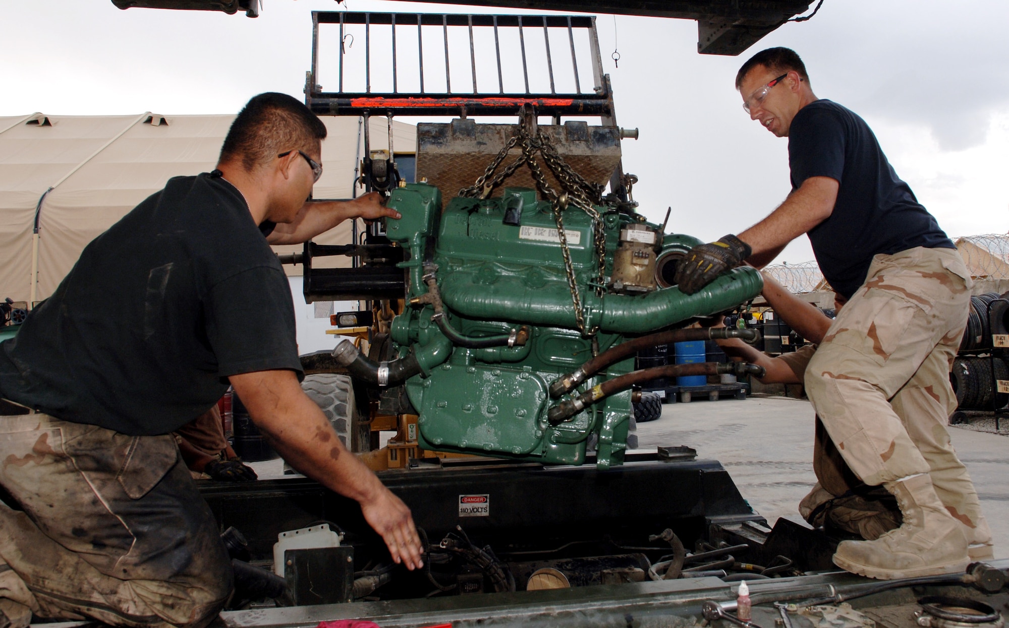 Staff Sgt. Fernando Mendiola, left, and Senior Airman Scott Lorenz help guide a new engine into a 60k aircraft loader with the assistance of a forklift. Sergeant Mendiola is a material handling equipment mechanic and Airman Lorenz is a multipurpose vehicle mechanic. (U.S. Air Force photo/Staff Sgt. Jennifer Redente) 