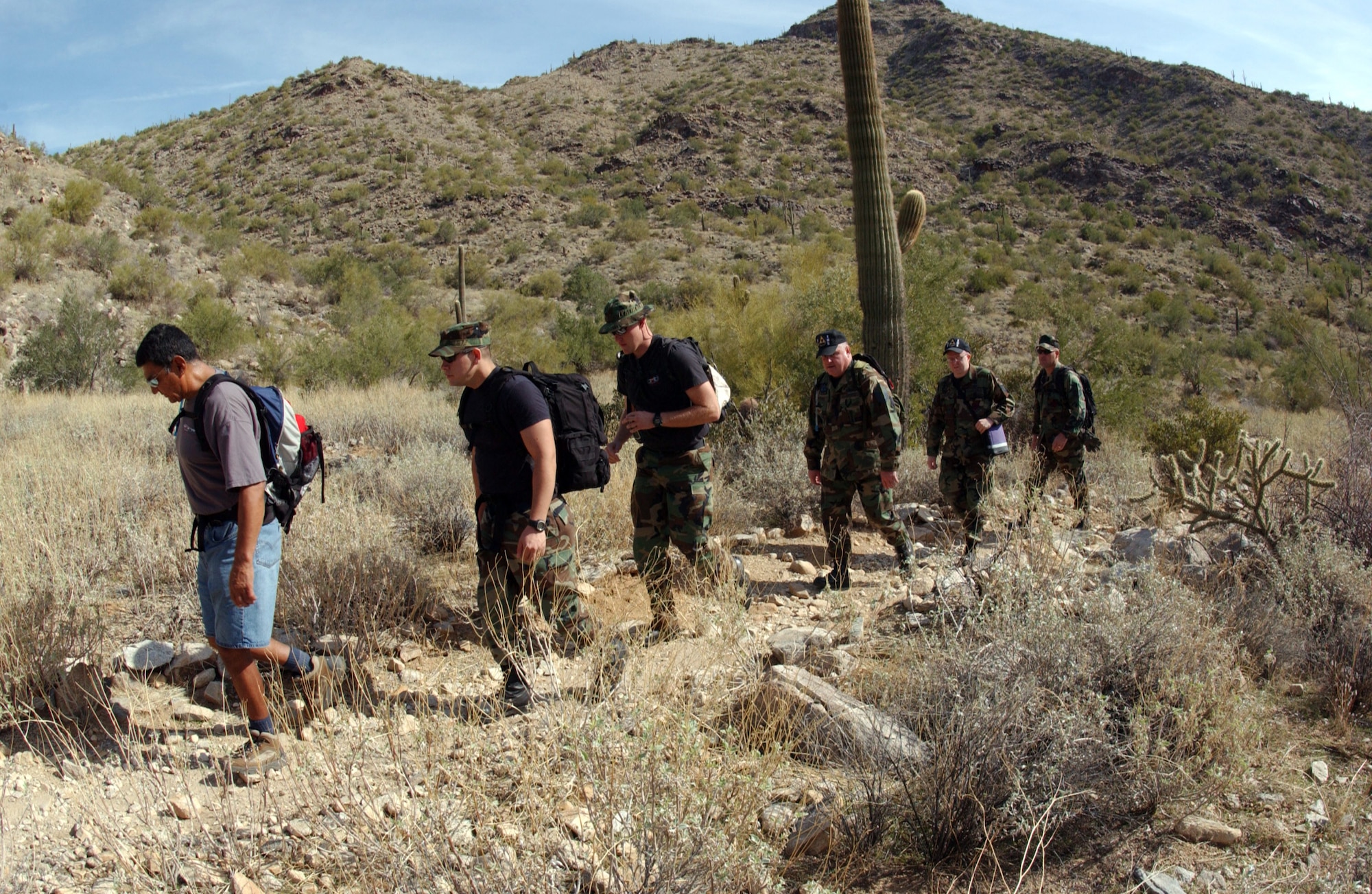 Airmen with the 56th Civil Engineer Squadron explosive ordnance disposal unit and the 56th Equipment Maintenance Squadron at Luke Air Force Base, Ariz., hike up the White Tank Mountains on Thursday, March 23, 2006. The group was going to the site of an F-16 Fighting Falcon triple ejector rack to ensure it didn't contain unexploded cartridges. The rack was released from a 61st Fighter Squadron F-16 during an in-flight emergency on Aug. 11, 2003.  A local resident found the item while hiking and led the Air Force team to the site. (U.S. Air Force photo/Tech. Sgt. Angela Clemens)