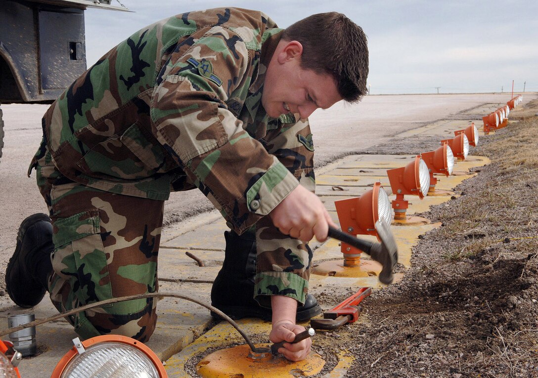 Airman Kody Schlageter fixes a light fixture on the flightline at Ellsworth Air Force Base, S.D., on Wednesday, March 29, 2006. The fixture was broken during the last snow storm.  Airman Schlageter is with the 28th Civil Engineer Squadron.  (U.S. Air Force photo/A1C Melissa Flores)