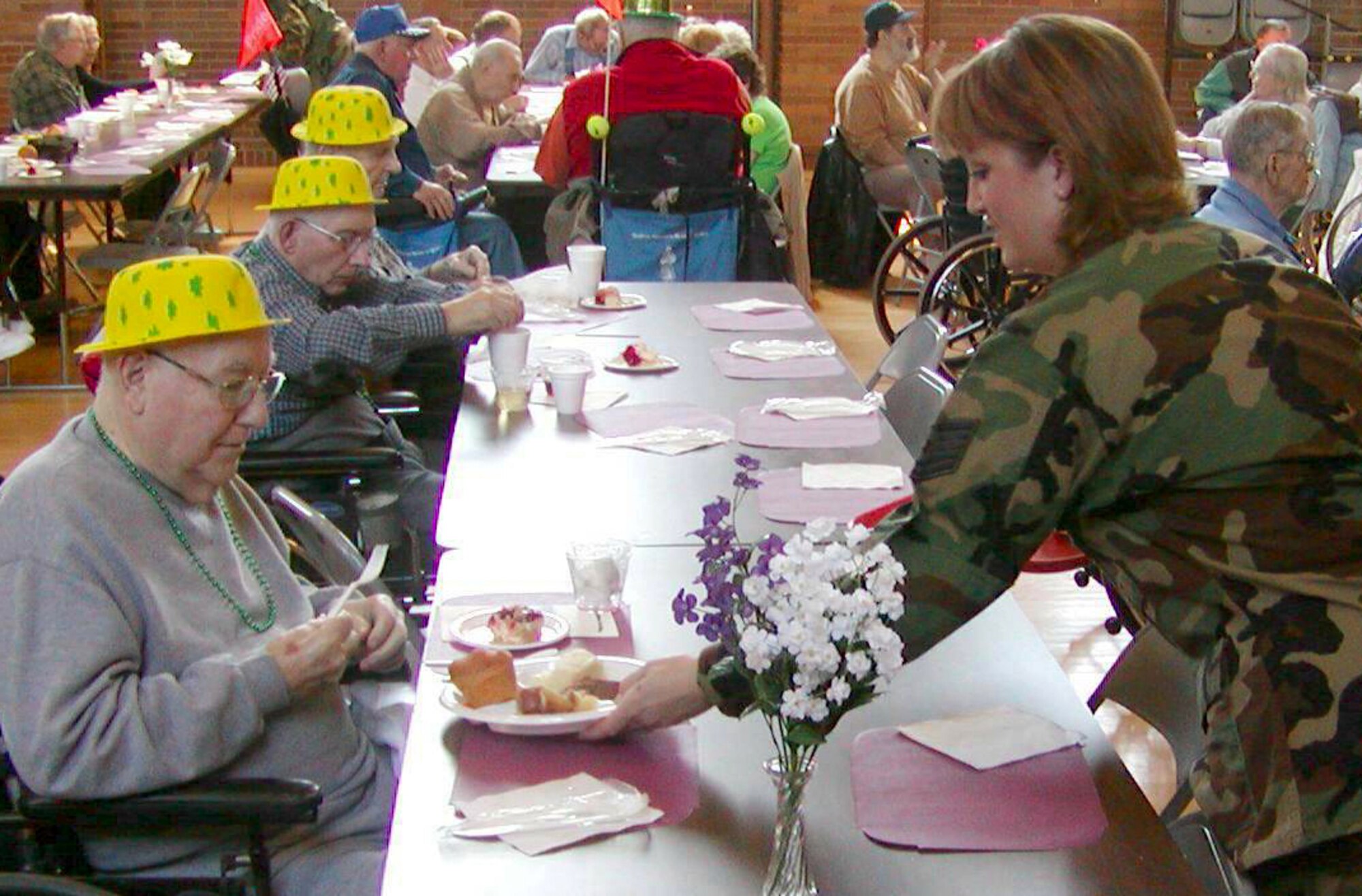 Tech. Sgt. Kristine Keyser, First Term Airmen Center instructor, serves a plate of food during the St. Patrick's Day celebration at the Quincy Veterans' Home.