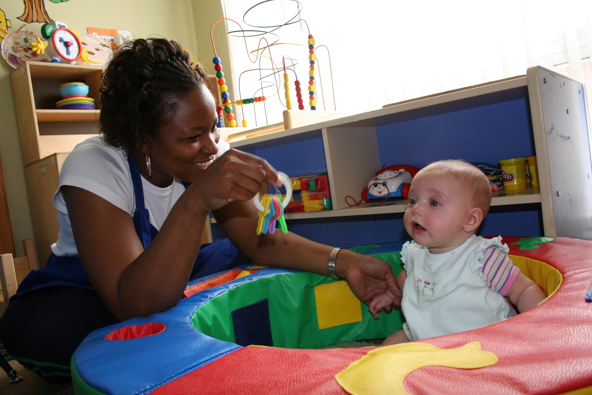 Jamie Lacy, (left) Incirlik Family childcare provider, plays with five-month-old Cassidy Moore while caring for the infant at her in-home daycare March 20.
(Photo by Staff Sgt. Oshawn Jefferson)