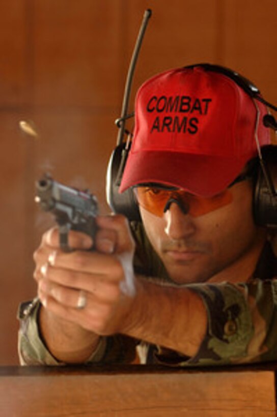 Shell casings fly as Air Force Staff Sgt. Christopher Oshana fires an M-9 handgun during proficiency training at MacDill Air Force Base, Fla., on March 27, 2006. Oshana is an Air Force combat arms training and maintenance instructor with the 6th Security Forces Squadron at MacDill. The instructors are required to fire 500 rounds a year on every small arms weapon they teach in order to stay proficient as instructors. 