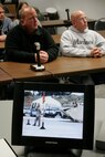 Kelly Kasal, left, and Kevin Kasal watch as their brother, Sgt. Maj. Bradley A. Kasal, is awarded the Navy Cross on May 1, 2006, via live video teleconference at the Southwestern Community College in Creston, Iowa. The VTC was arranged in order to allow Gerald Kasal, the Marine's severely ill father who couldn't travel, to witness the ceremony. Unfortunately, he passed away on April 30. Kasal, who was also promoted to the rank of sergeant major during the ceremony at Camp Pendleton, Calif., earned the Marine Corps' second highest award for combat heroism by selflessly shielding a Marine from an exploding grenade thus saving his life in Fallujah, Iraq, in November 2004. Kasal, a 39-year-old native of Afton, Iowa, is scheduled to return to his home state at the end of May to serves as the sergeant major of the Marine Corps recruiting station headquartered in Des Moines. (Photo by Staff Sgt. Bill Lisbon)