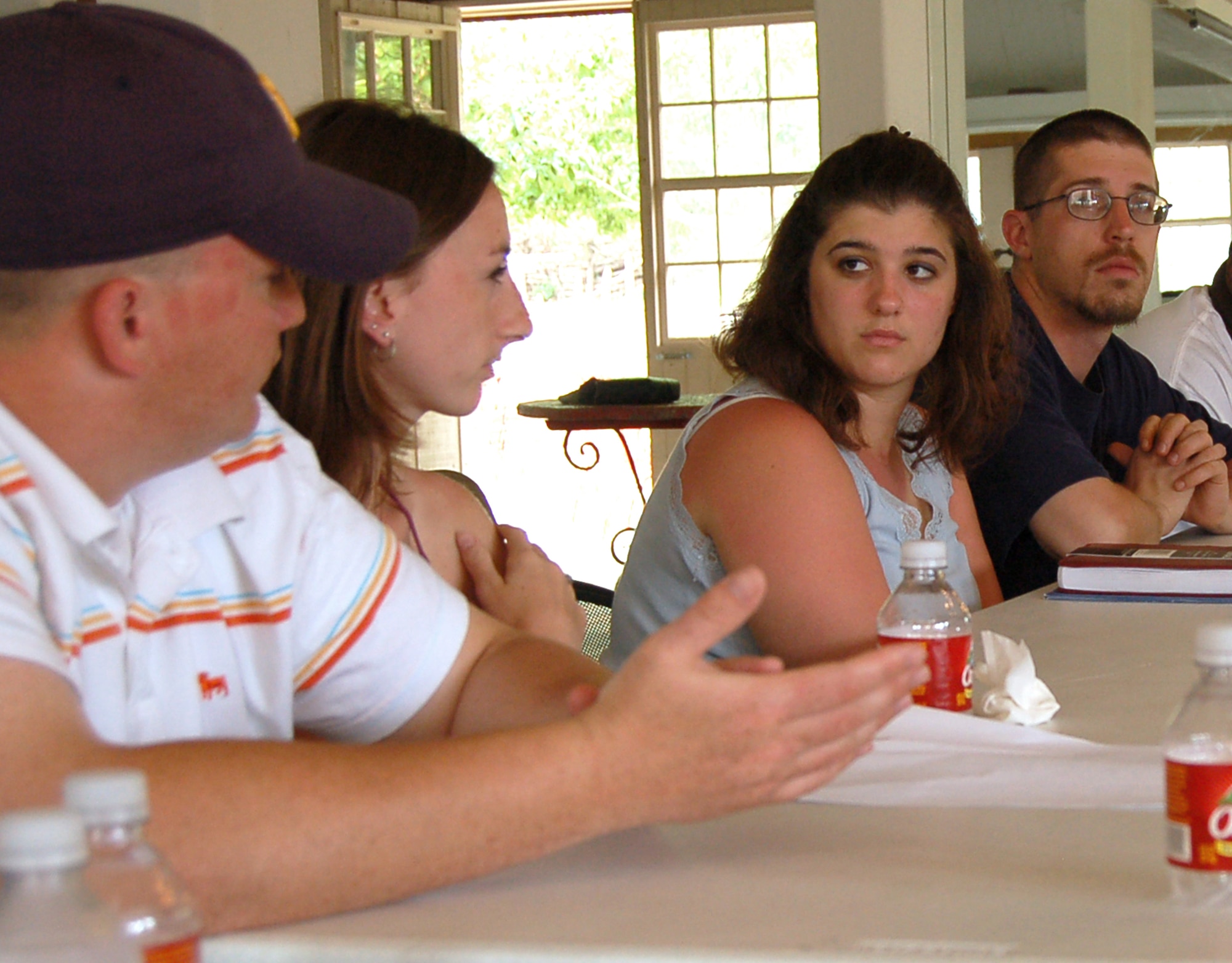 (Left to right) Senior Airman Aaron Childs and his wife, Mellissa, talk with Army Sgt. Jenifer Behlke and her husband, Army Sgt. Jon Behlke, during a retreat in Hunt, Texas, on Sunday, April 23, 2006. Group discussions on family separation were part of the activities at the retreat hosted by the Military, Veteran and Family Assistance Foundation at the Heart of the Hills Camp. The retreat helps couples reconnect after the military spouse returns from a deployment. (U.S. Air Force photo/Louis A. Arana-Barradas)