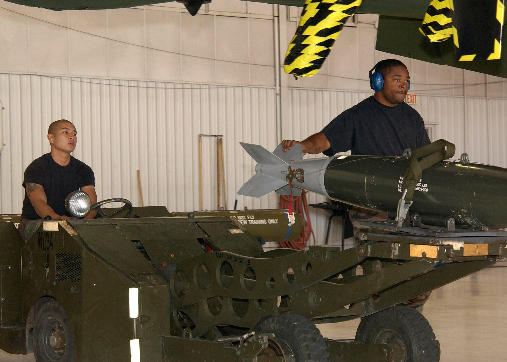 Staff Sgt. Jevon Charles guides the missile as Airman First Class Bho DeLosSantos drives it to an A-10 Thunderbolt II during the 355th Wing "Load Crew of the Quarter" competition on Thursday, April 27, 2006, at Davis-Monthan Air Force Base, Ariz. The 354th, 357th and 358th Aircraft Maintenance Units are competing for the title. Sergeant Charles and Airman DeLosSantos are with the 358th AMU. (U.S. Air Force photo/Airman Gary Walker)
