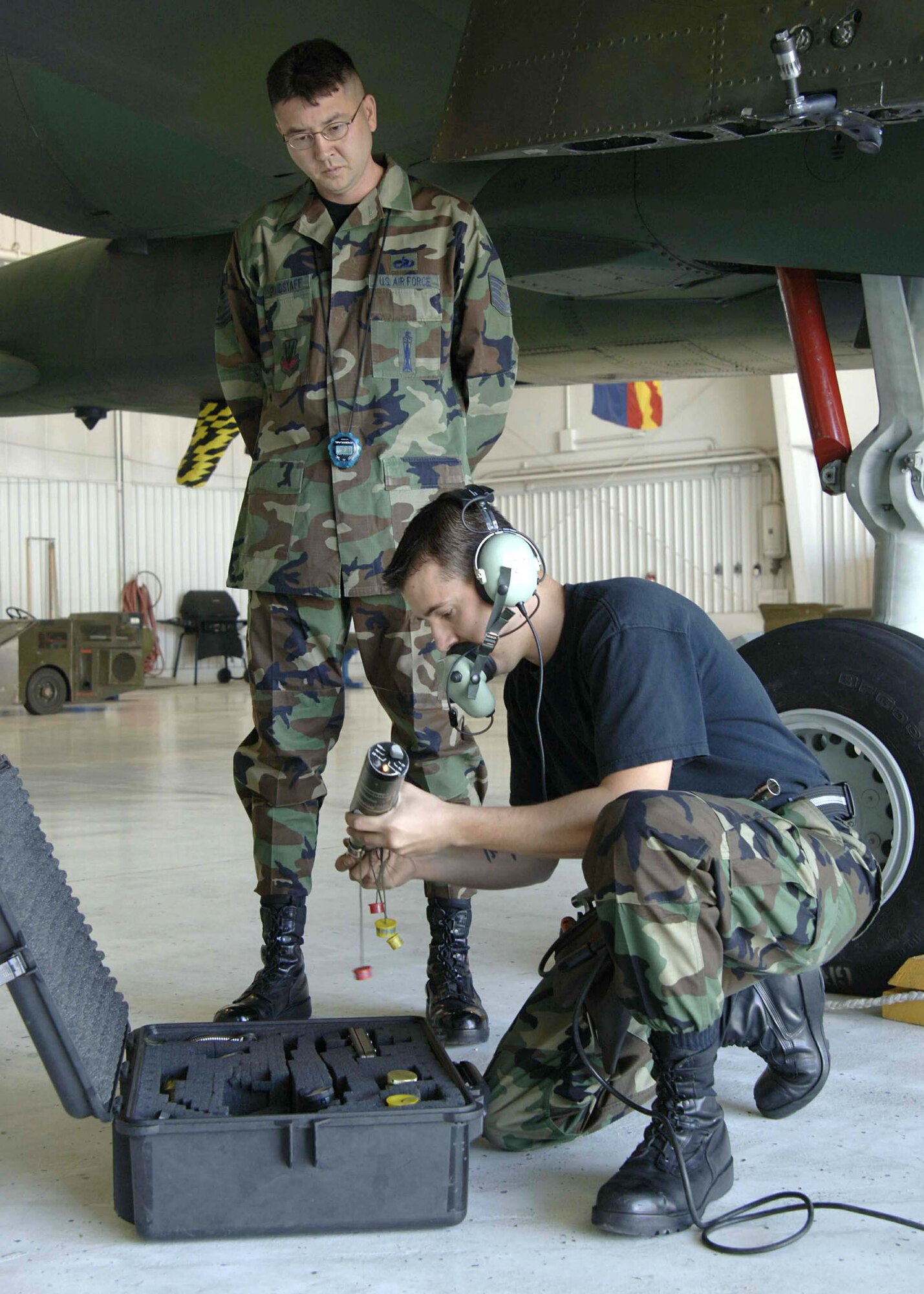 Tech. Sgt. Thomas Grandstaff evaluates Senior Airman Joseph Harrison during the 355th Wing "Load Crew of the Quarter" competition on Thursday, April 27, 2006, at Davis-Monthan Air Force Base, Ariz. The 354th, 357th and 358th Aircraft Maintenance Units are competing for the title. Sergeant Grandstaff is a loading standardization crew member. Airman Harrison is with the 357th AMU. (U.S. Air Force photo/Senior Airman Christina D. Ponte)
