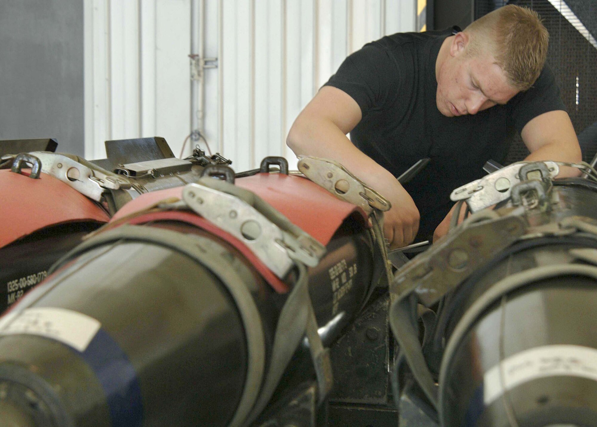 Airman 1st Class Kevin Shelton prepares munitions before loading operations at the 355th Wing "Load Crew of the Quarter" competition on Thursday, April 27, 2006, at Davis-Monthan Air Force Base, Ariz. Teams from the 354th, 357th and 358th Aircraft Maintenance Units are competing for the title. Airman Shelton is with the 357th AMU. (U.S. Air Force photo/Senior Airman Christina D. Ponte)