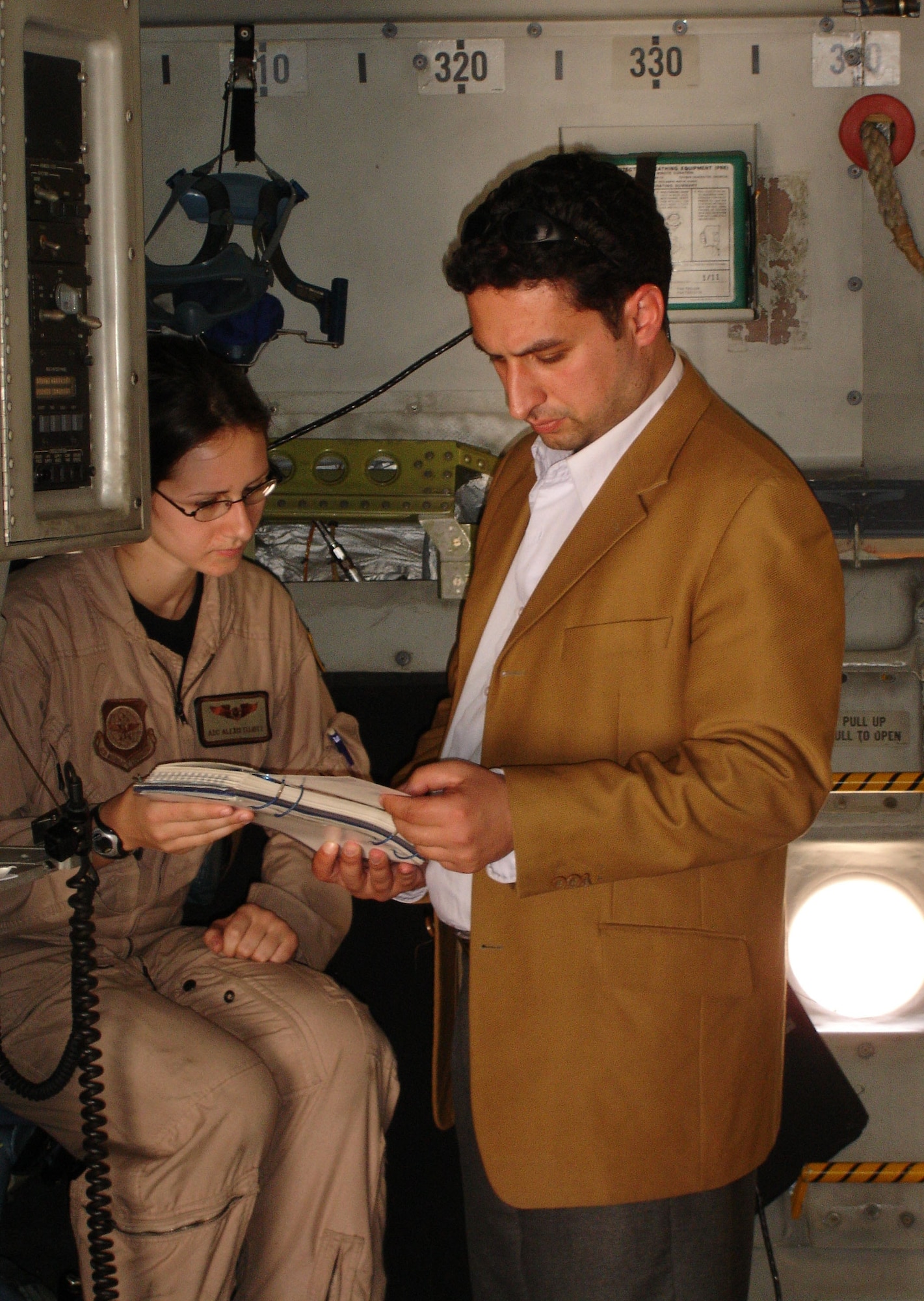 Airman 1st Class Alexis Elliott, a C-17 loadmaster, helps Dr. Talib, a plastic surgery resident, give the preflight safety briefing in Arabic for the Iraqi children and parents of Operation Smile.  Operation Smile is a non-governmental organization that treats children for cleft palate and cleft lip, a congenital birth defect.  On Saturday, the United States Air Force assisted Operation Smile in returning patients and their families to Iraq from Jordan, where the patients had received surgery. (U.S. Air Force Photograph by Maj. Robert Palmer)

