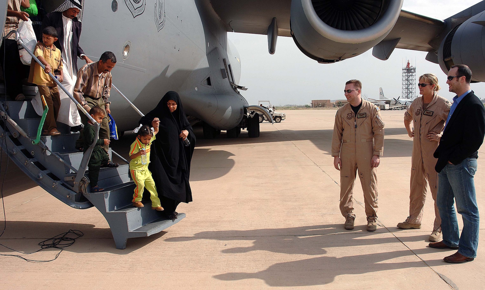 Iraqi children and their escorts deplane a U.S. Air Force C-17 Globemaster III at Baghdad International Airport, Iraq, April 29 as Chris Anderson, an Operation Smile staff member based in the Middle East looks on. On Saturday, the United States Air Force assisted Operation Smile in returning patients and their families to Iraq from Jordan, where the patients had received surgery. (U.S. Air Force Photograph by Master Sgt. Will Ackerman)