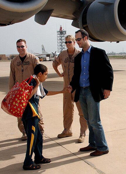 An Iraqi boy thanks Christopher Anderson of Operation Smile after deplaning a U.S. Air Force C-17 Globemaster III at Baghdad International Airport, Iraq, April 29. On Saturday, the United States Air Force assisted Operation Smile in returning patients and their families to Iraq from Jordan, where the patients had received surgery. (U.S. Air Force Photograph by Master Sgt. Will Ackerman)