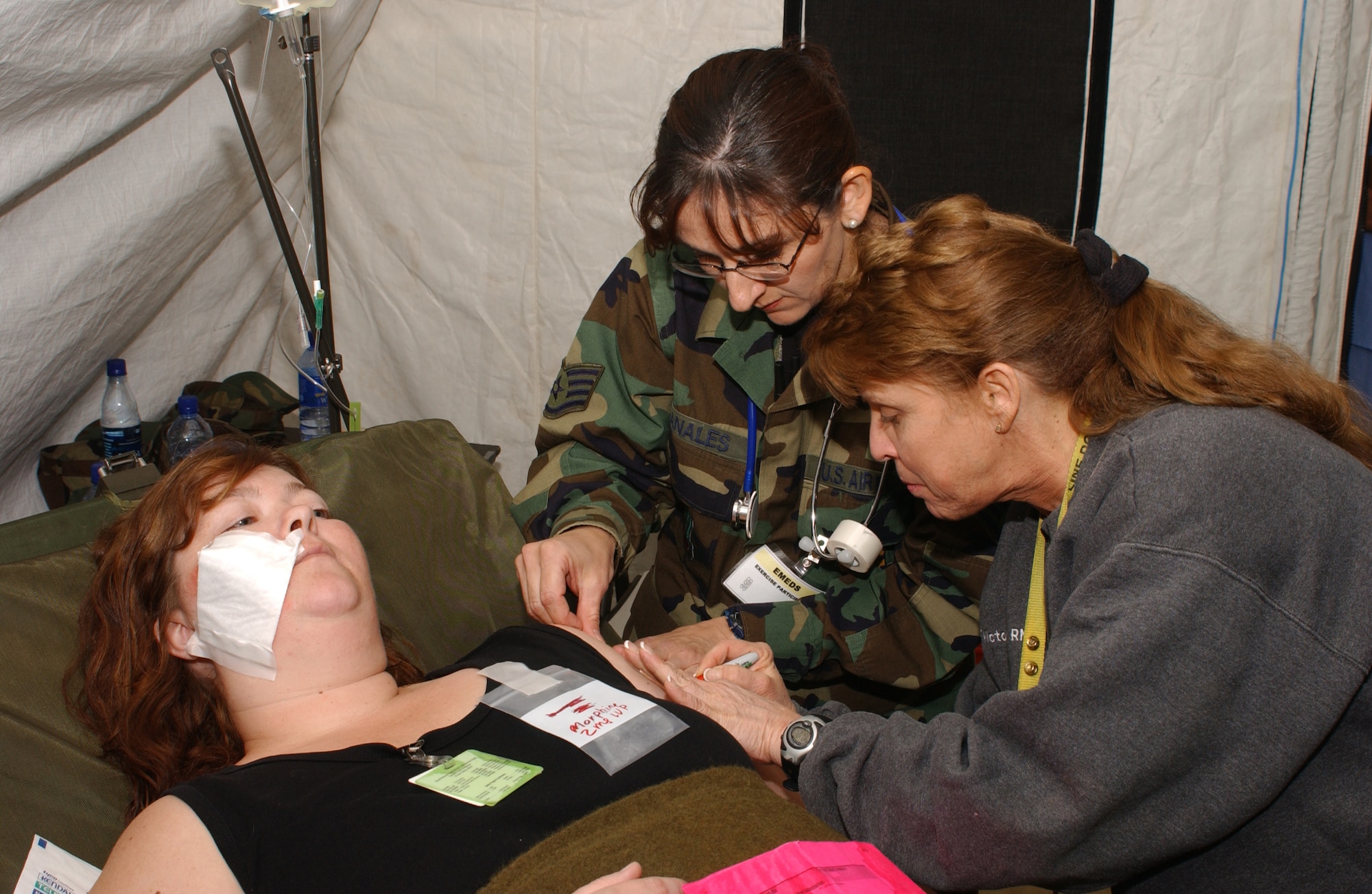 Staff Sgt. Frances Banales, 944th Medical Squadron medical technician, and Victoria Wray, a nurse from the Maricopa Medical Center, treat Amber Ingraham, a simulated patient during the Coyote Crisis Campaign exercise April 26, 2006 in Phoenix. (U.S. Air Force photo/Master Sgt. Garrett McClure) 