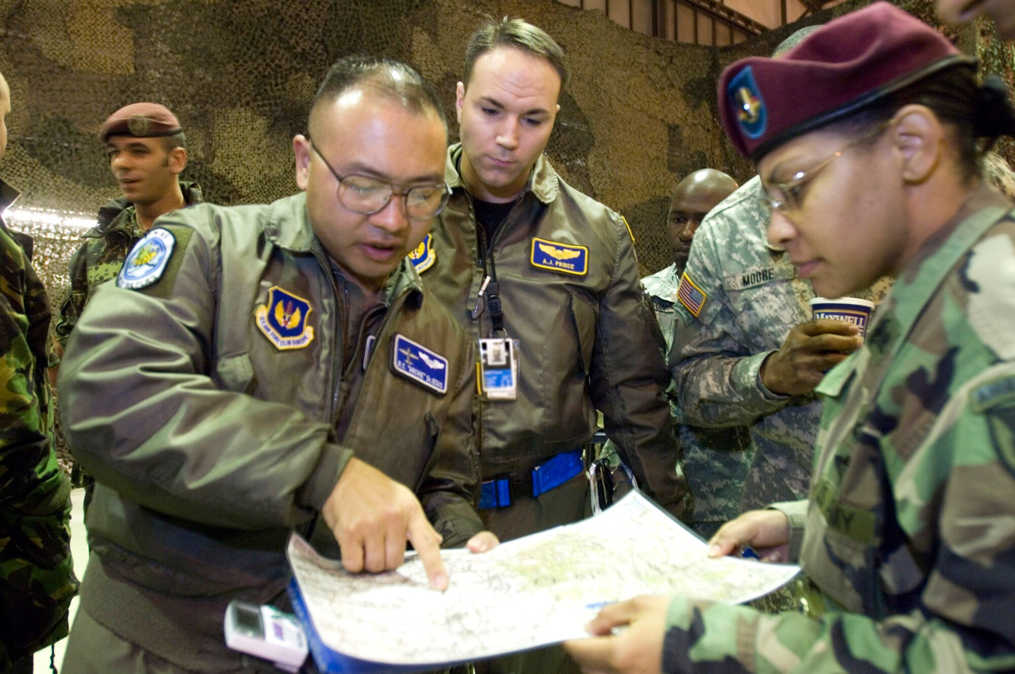 (Left to right) Capts. Ramoncarlos DeJesus and Aaron Prince discuss the day's paratrooper mission with Army Chief Warrant Officer 4 Petrice McKey at Ramstein Air Base, Germany, on Thursday, April 27, 2006. Captains DeJesus and Prince are C-130 Hercules crewmembers from the 37th Airlift Squadron at Ramstein. Warrant Officer McKey is with the 5th Quartermaster Detachment at nearby Kleber Kaserne. (U.S. Air Force photo/Master Sgt. John E. Lasky)