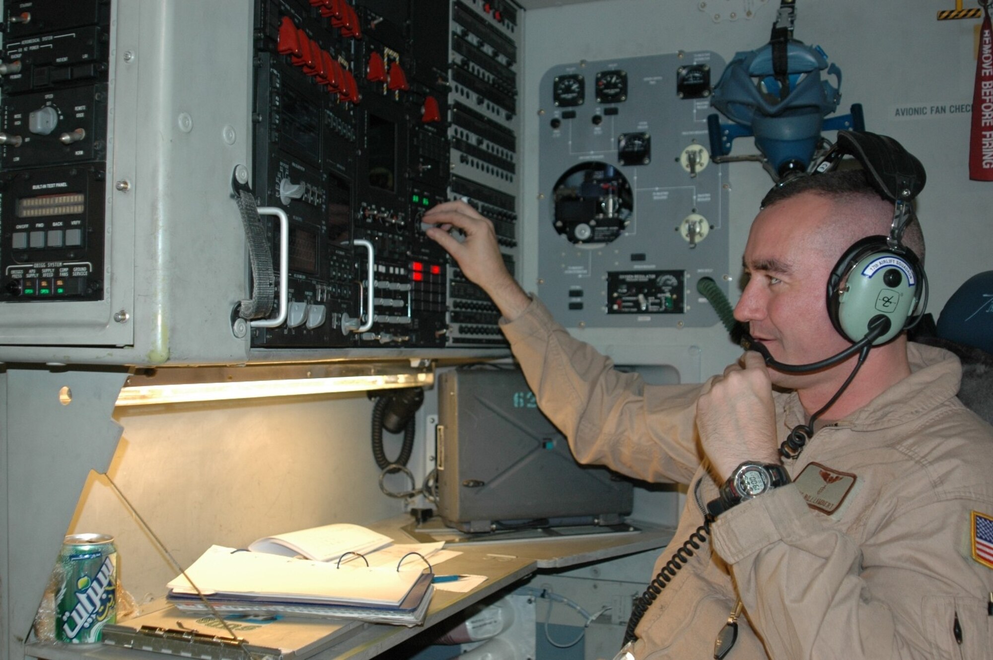 Master Sgt. Bill Lambert, 817th Expeditionary Airlift Squadron Detachment 2 loadmaster, changes settings on a radio system in a C-17 Globemaster III. Members of the 817th EAS Det. 2 are deployed here, flying missions throughout the AOR. (Photo by Maj. Ann Peru Knabe)