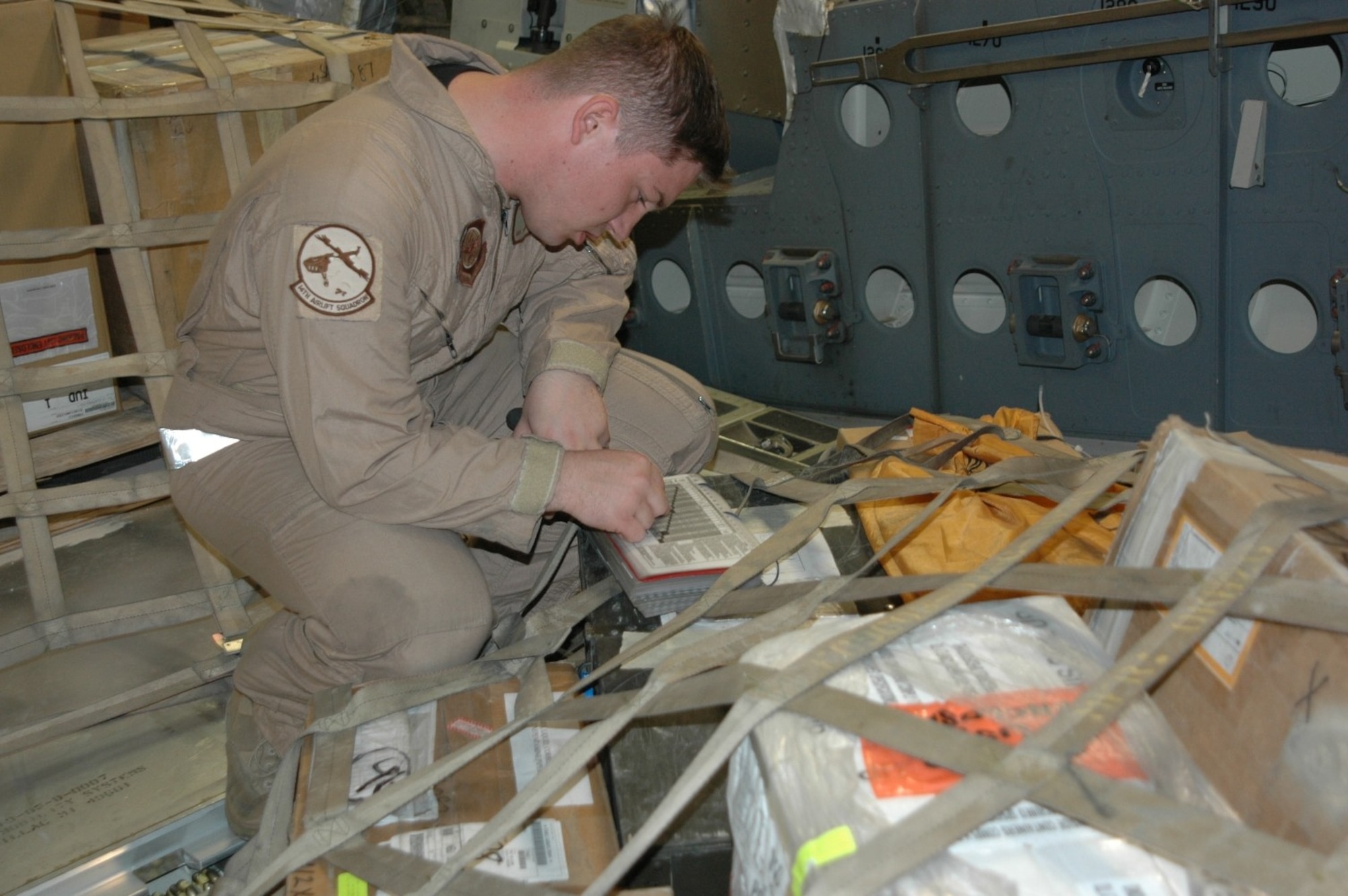 Senior Airman Steve Baird, 817th Expeditionay Airlift Squadron Detachment 2 loadmaster, reviews a cargo list on a mission in Southwest Asia. The 817th EAS  Det. 2 flies C-17 Globemaster IIIs througout the AOR carrying troops and supplies. (Photo by Maj Ann Peru Knabe)