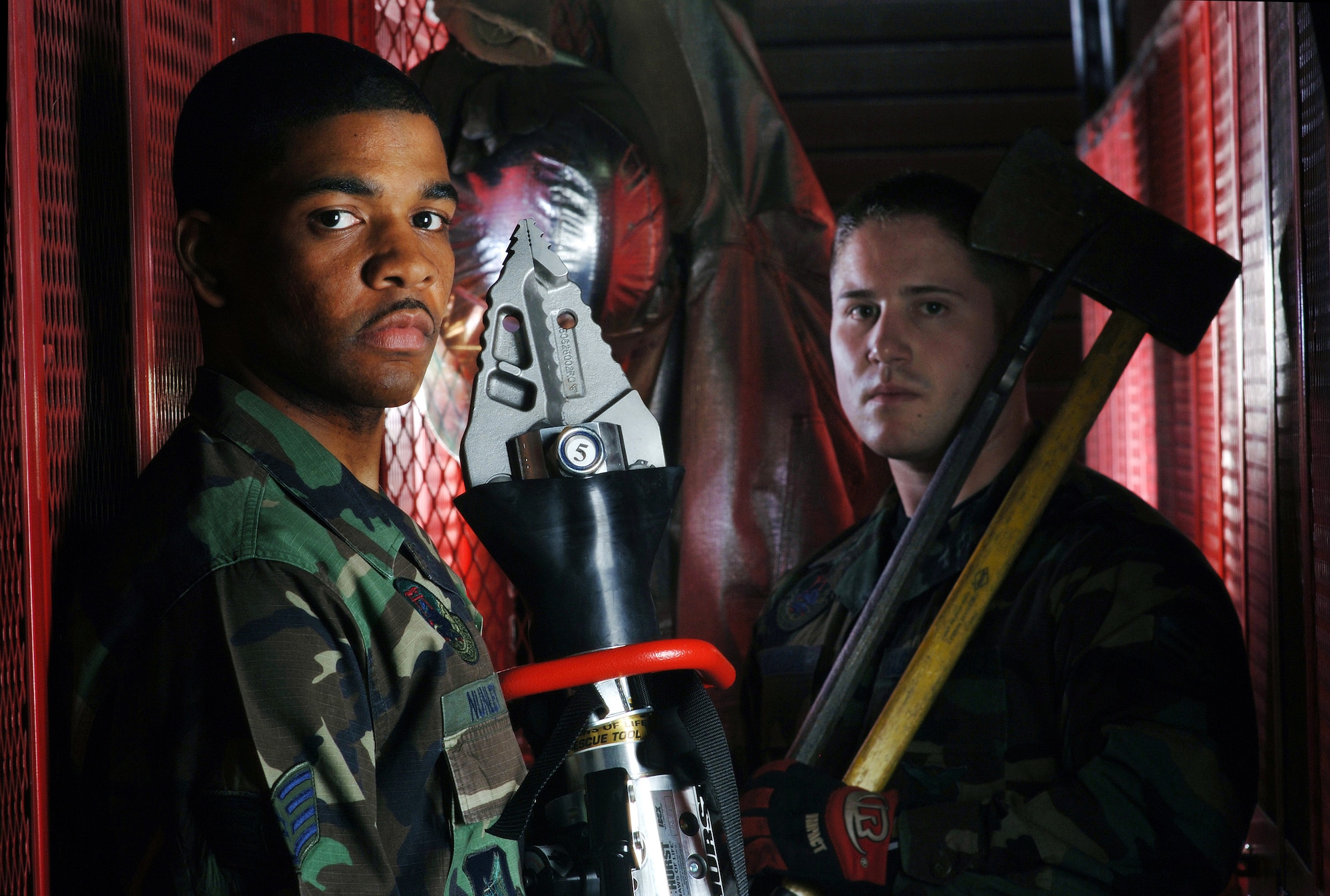 Staff Sgt. Gary Nunley (left) holds a Jaws of Life while Senior Airman Christopher Provencal carries a bar and ax. They are on their way to field training at Yokota Air Base, Japan, on Friday, April 28, 2006. Both Airmen are firefighters with the 374th Civil Engineer Squadron. (U.S. Air Force photo/Val Gempis)
