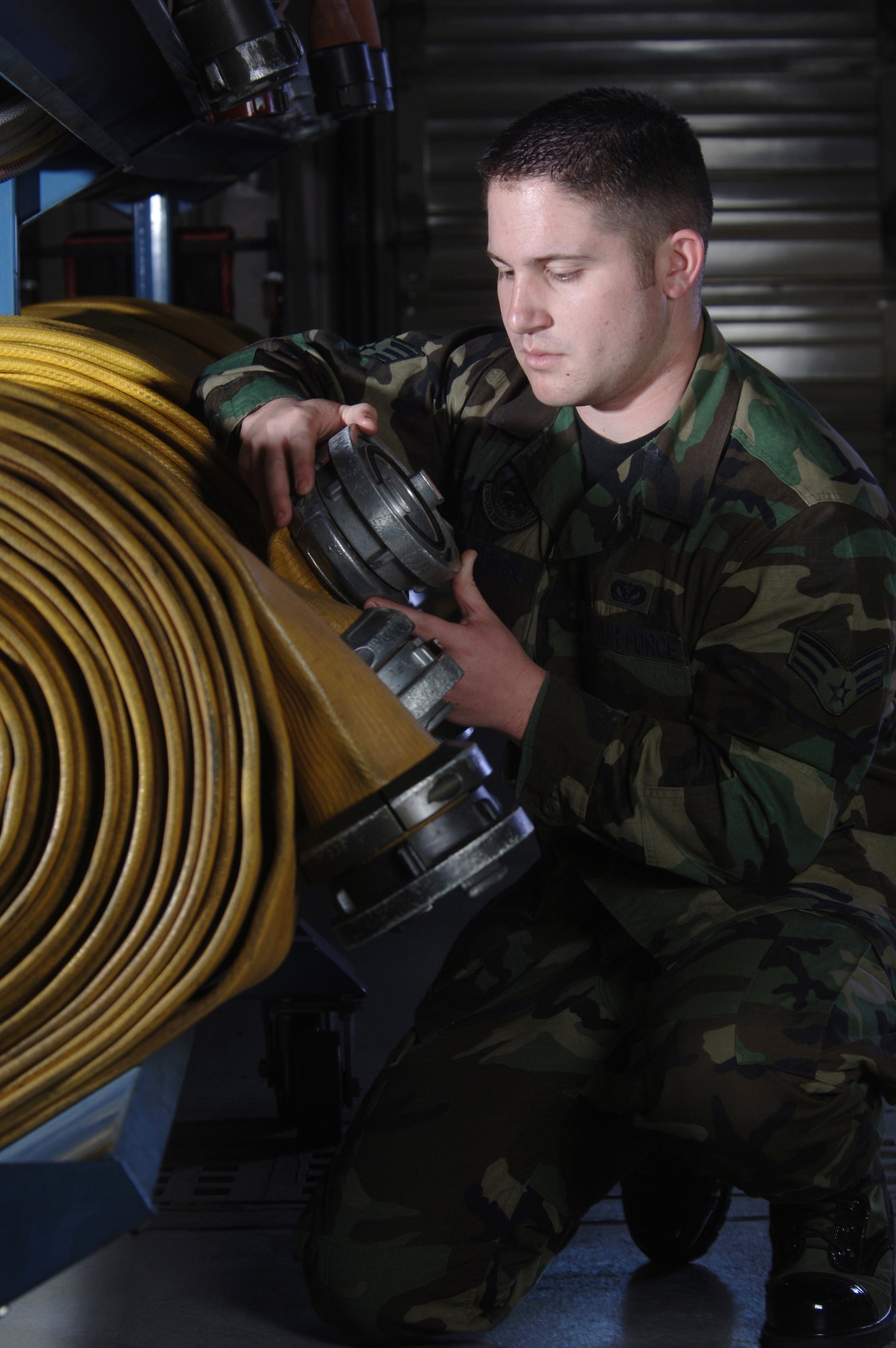 Senior Airman Christopher Provencal inspects water hoses for defects at Yokota Air Base, Japan, on Friday, April 28, 2006. Airman Provencal is a firefighter with the 374th Civil Engineer Squadron. (U.S. Air Force photo/Val Gempis)
