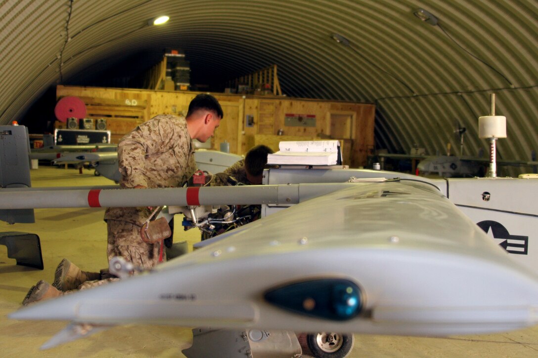 Lance Cpl. Derek A. Williams (left) and Lance Cpl. Philip Buttiens remove the engine of an RQ-2B Pioneer unmanned aerial vehicle at Al Taqaddum, Iraq, May 2. Both Marines are UAV mechanics with Marine Unmanned Aerial Vehicle Squadron 2, Marine Air Control Group 38 (Reinforced), 3rd Marine Aircraft Wing. Williams is a 20-year-old native of Watseka, Ill., and Buttiens is a 21-year-old New Town, Pa., native.