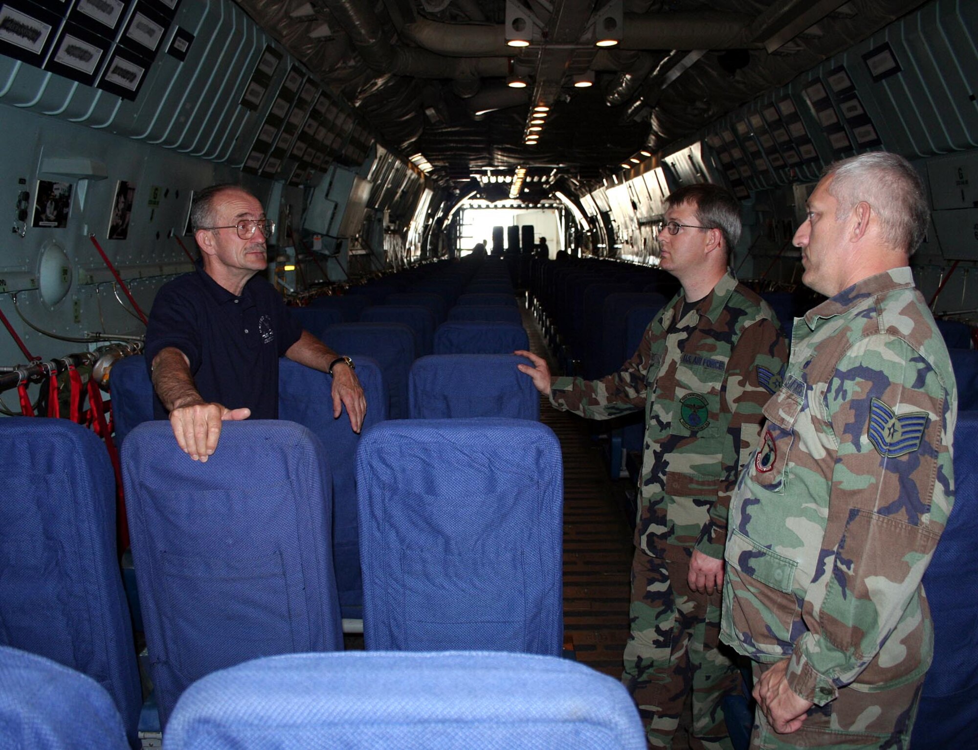 Retired Maj, Gen. Edward J. Mechenbier talks about the maintenance of the 'Hanoi Taxi', a C-141 Starlifter, with Staff Sgt. Jeremy First and Tech. Sgt. Mike Heaton, Air Force Reservists with the 445th Airlift Wing at Wright-Patterson Air Force Base, Ohio on May 3. General Mechenbier, a former Prisoner of War was repatriated by the 'Hanoi Taxi' durning Operation Homecoming. General Mechenbier and about 120 other former POWs will take part in a weekend of aircraft retirement events May 5 and 6.  (U.S. Air Force Photo/Senior Airman Kenny Kimbrell)