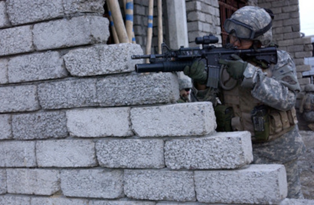Army Pfc. Douglas Dalton uses his optical sights to scan down the street during a joint neighborhood patrol in Mosul, Iraq, on May 2, 2006. Dalton is attached to the 2nd Battalion, 1st Infantry Regiment, 172nd Infantry Brigade Combat Team. 